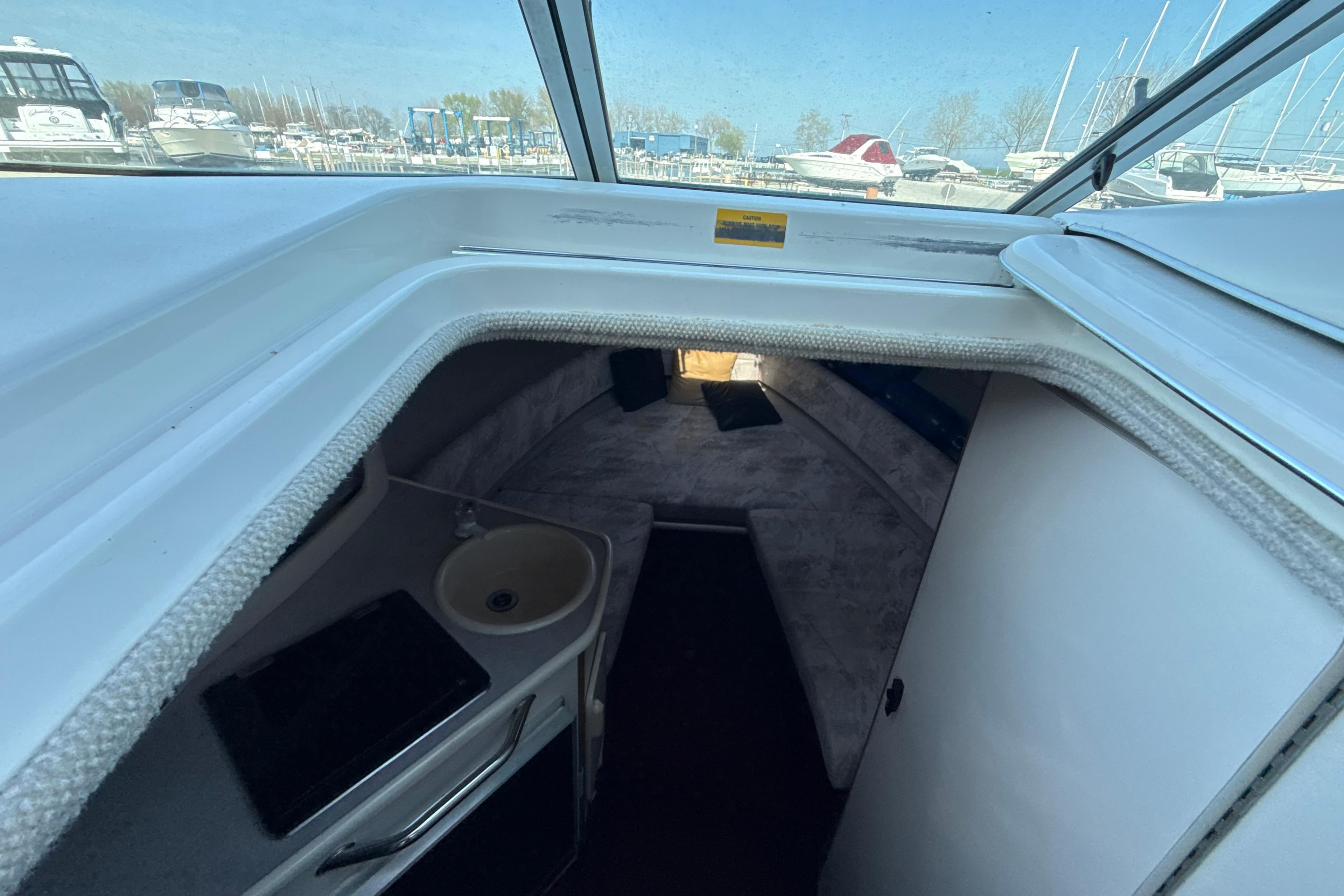 Interior cabin of 1996 Sea Ray 240 Sundancer boat with sink and seating area.
