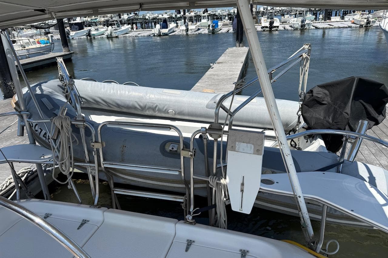 Catalina 380 sailboat from 1998 docked with inflatable dinghy at marina.