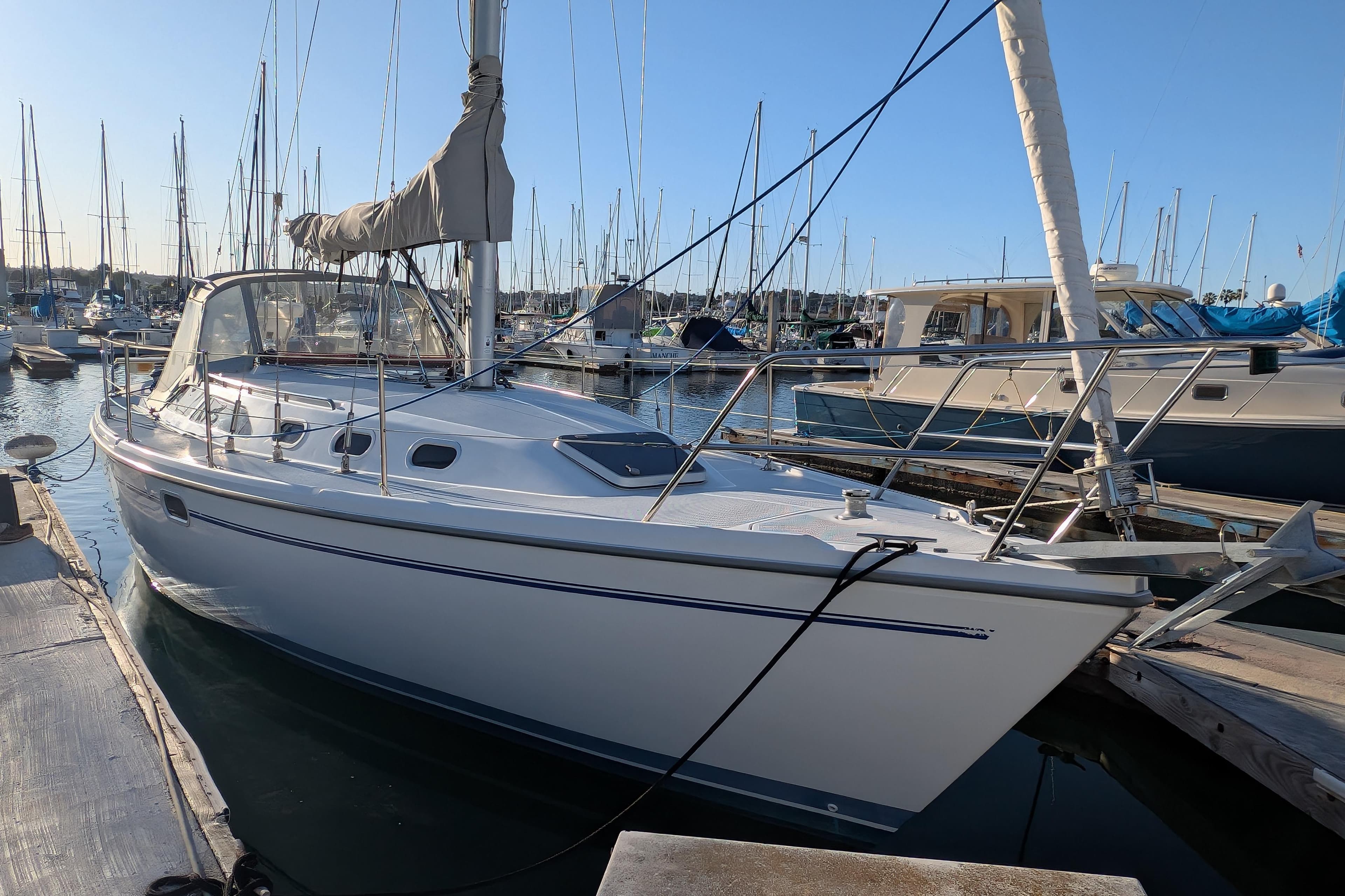 2003 Catalina 34 MkII sailboat docked in a marina under clear blue skies.