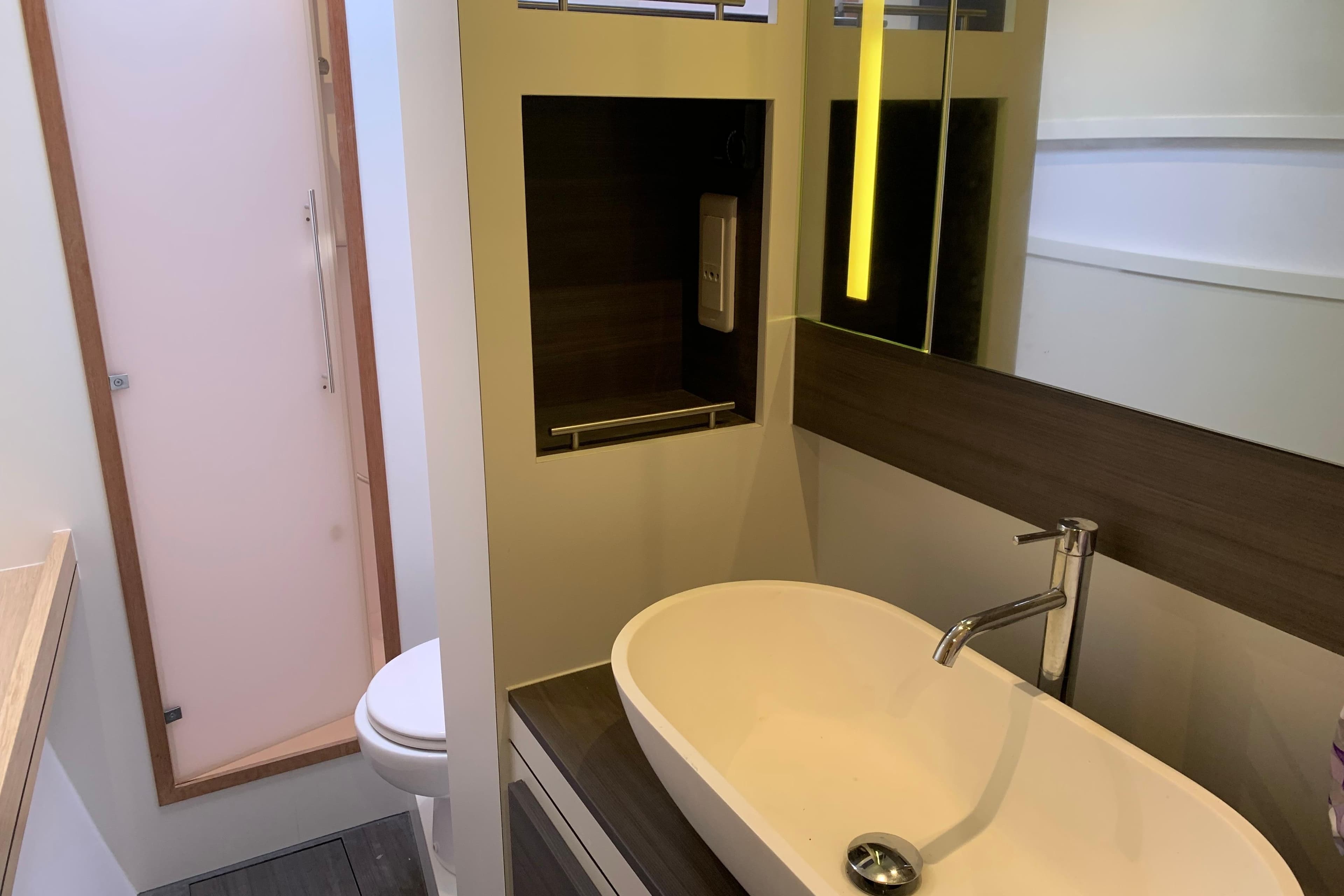 Modern bathroom interior of 2021 Outremer 51 yacht with sleek sink and mirror.