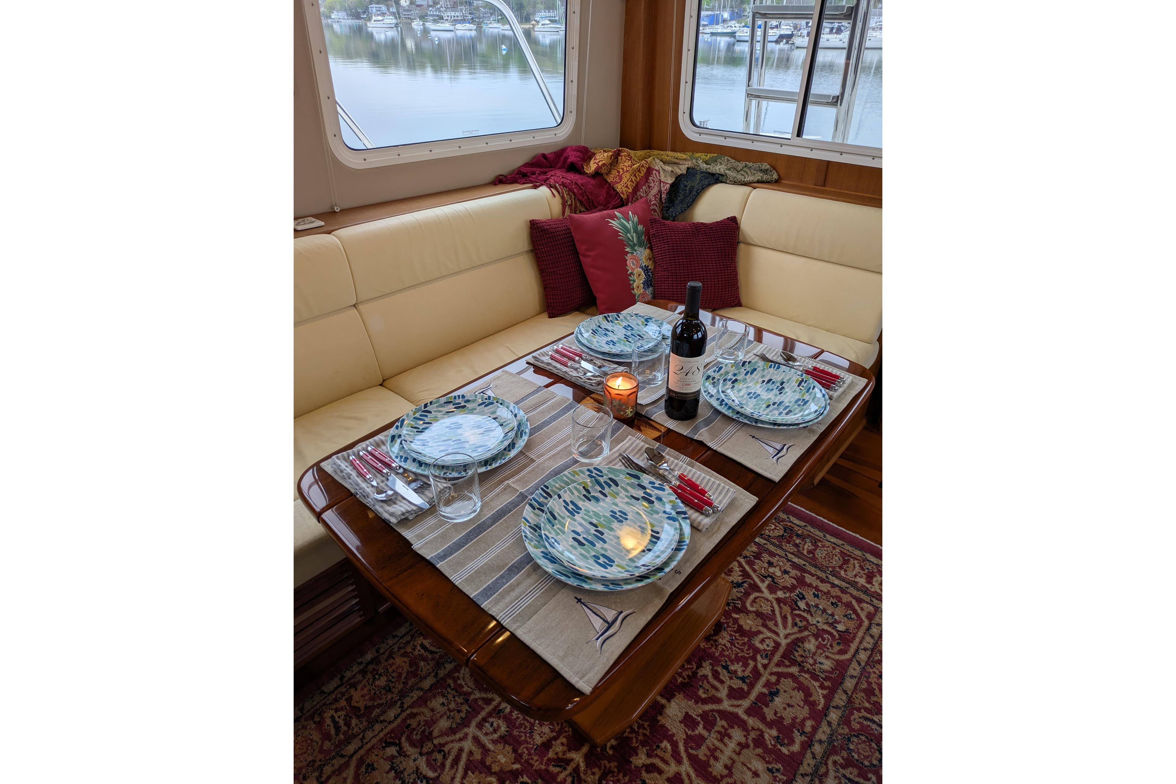 Elegant dining setup in 2005 American Tug 41 yacht interior with scenic window view.