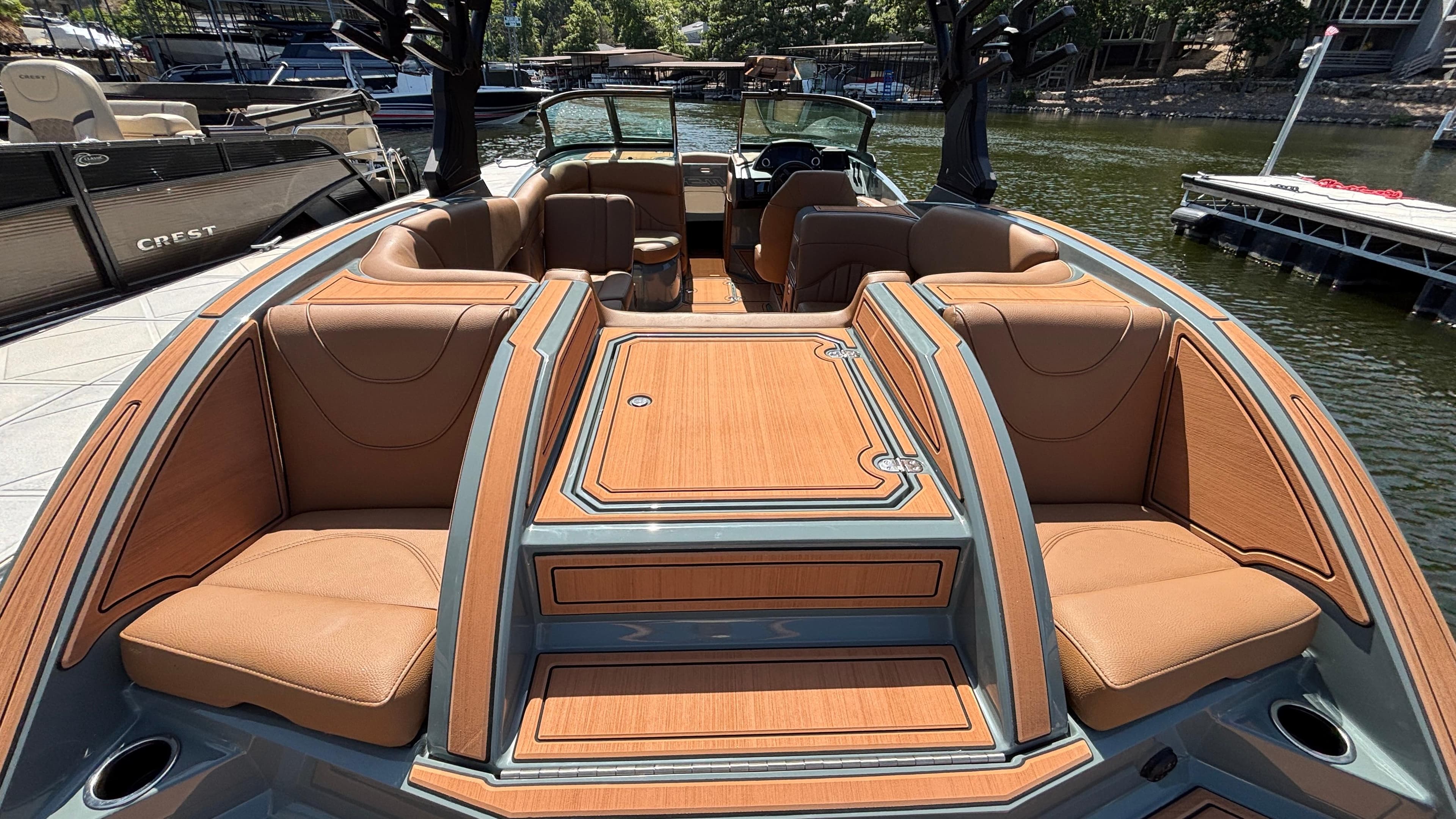 2025 MB B52 25 Alpha boat with luxurious tan seating and sleek design on a sunny dock.