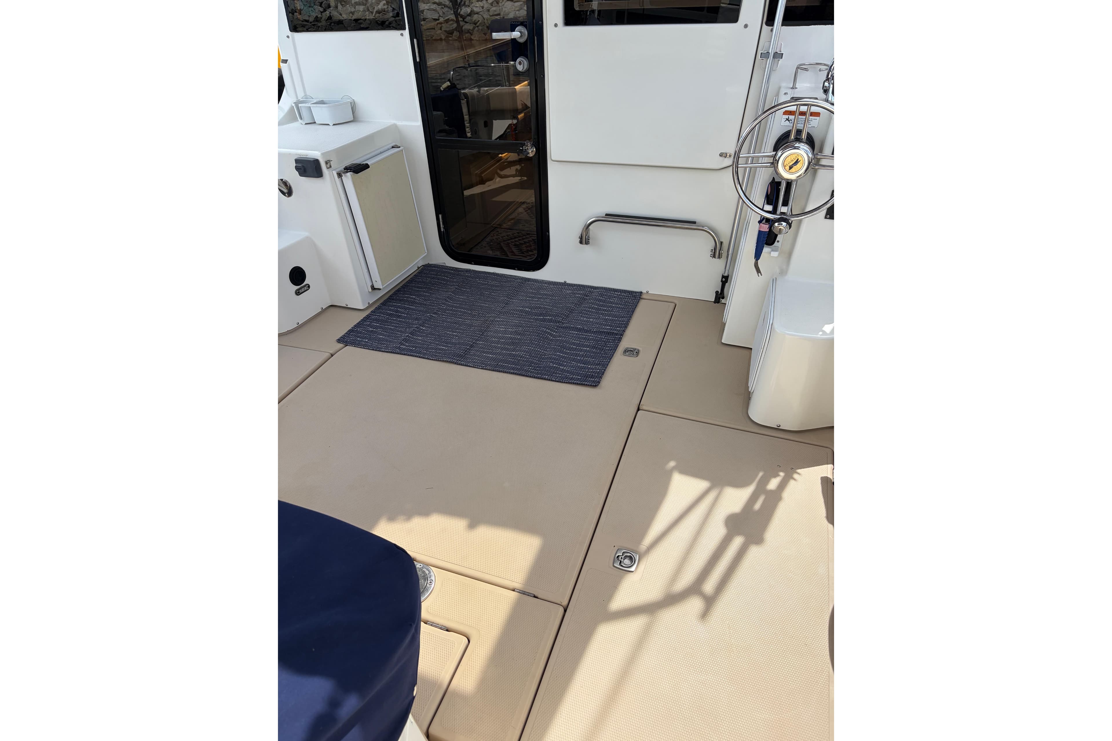 2014 Cutwater C-30 Sedan boat deck with steering wheel and door.