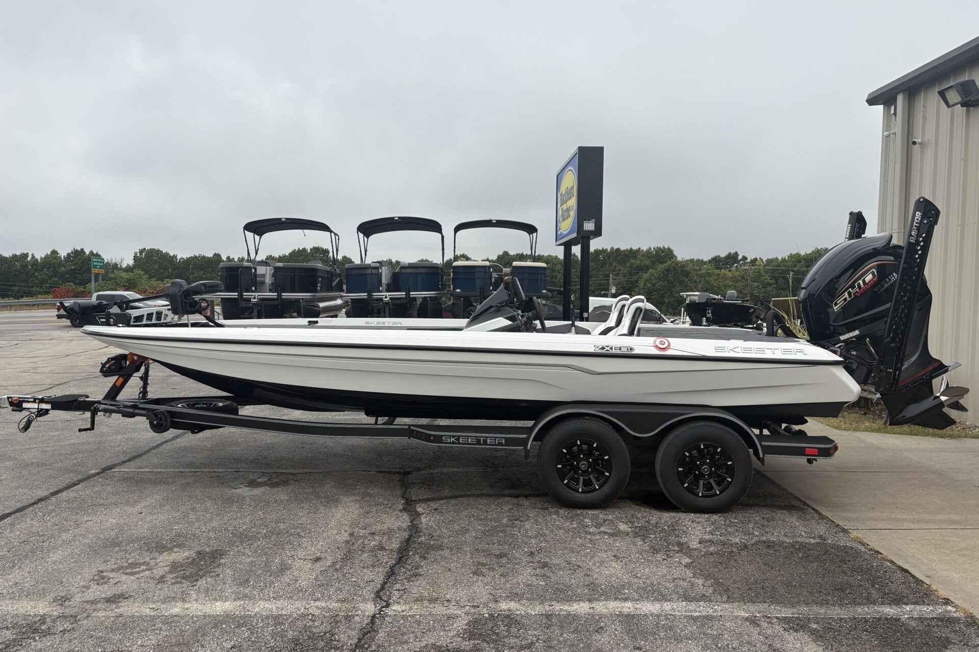 2026 Skeeter ZXE21 boat on trailer, parked outdoors near a building.