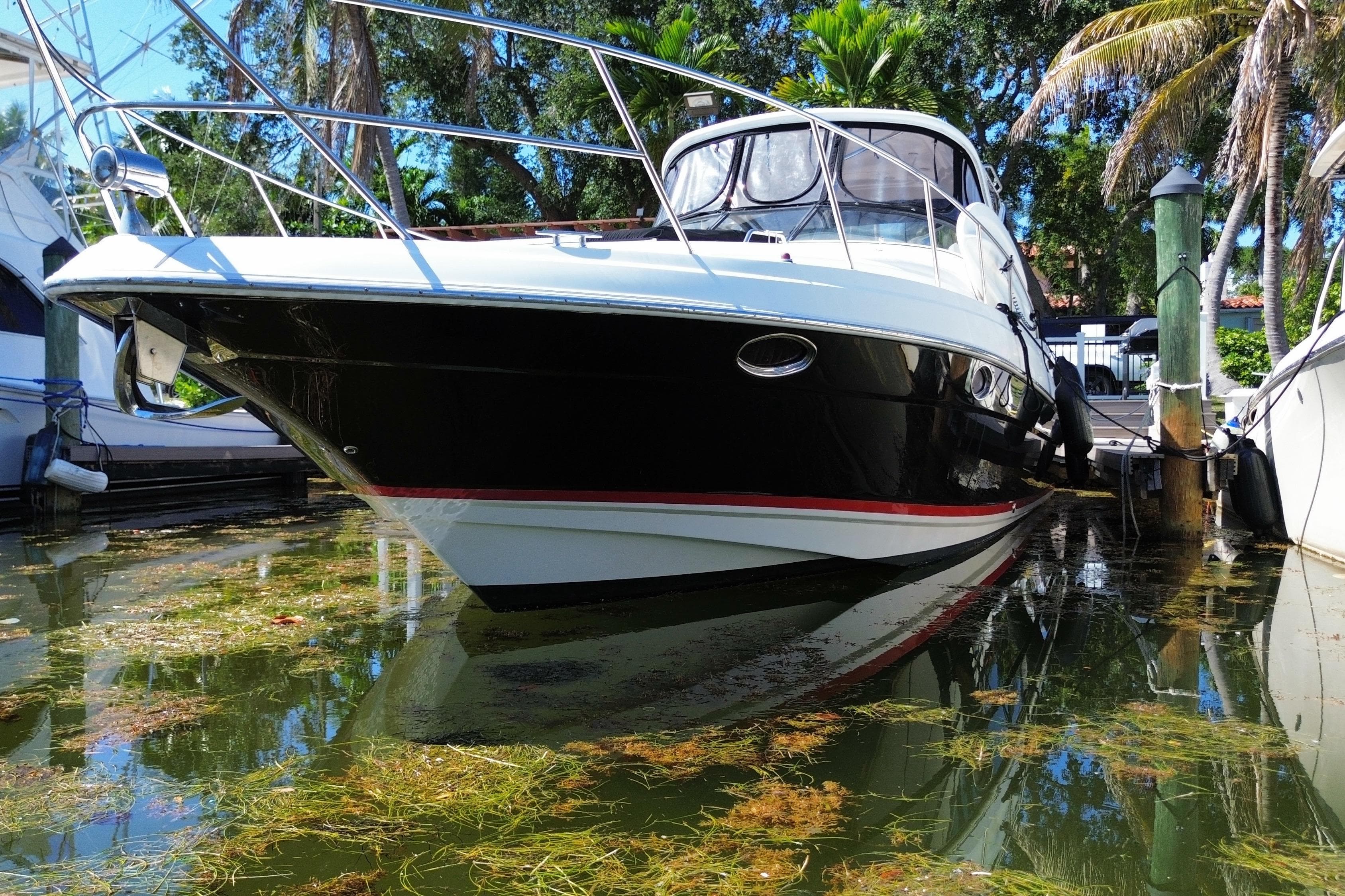 2006 Regal Commodore 3560 IB yacht docked in a lush marina setting.