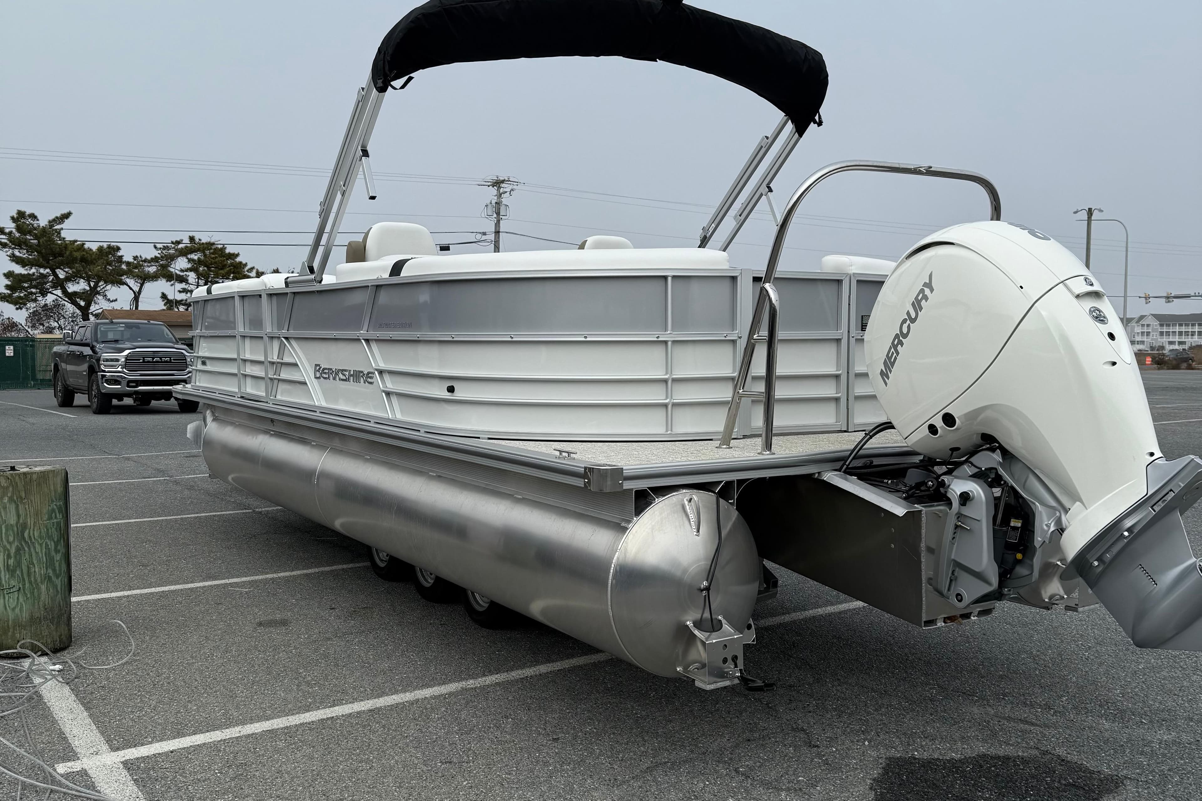 2026 Berkshire 24 RFX CTS pontoon boat with Mercury engine in parking lot.
