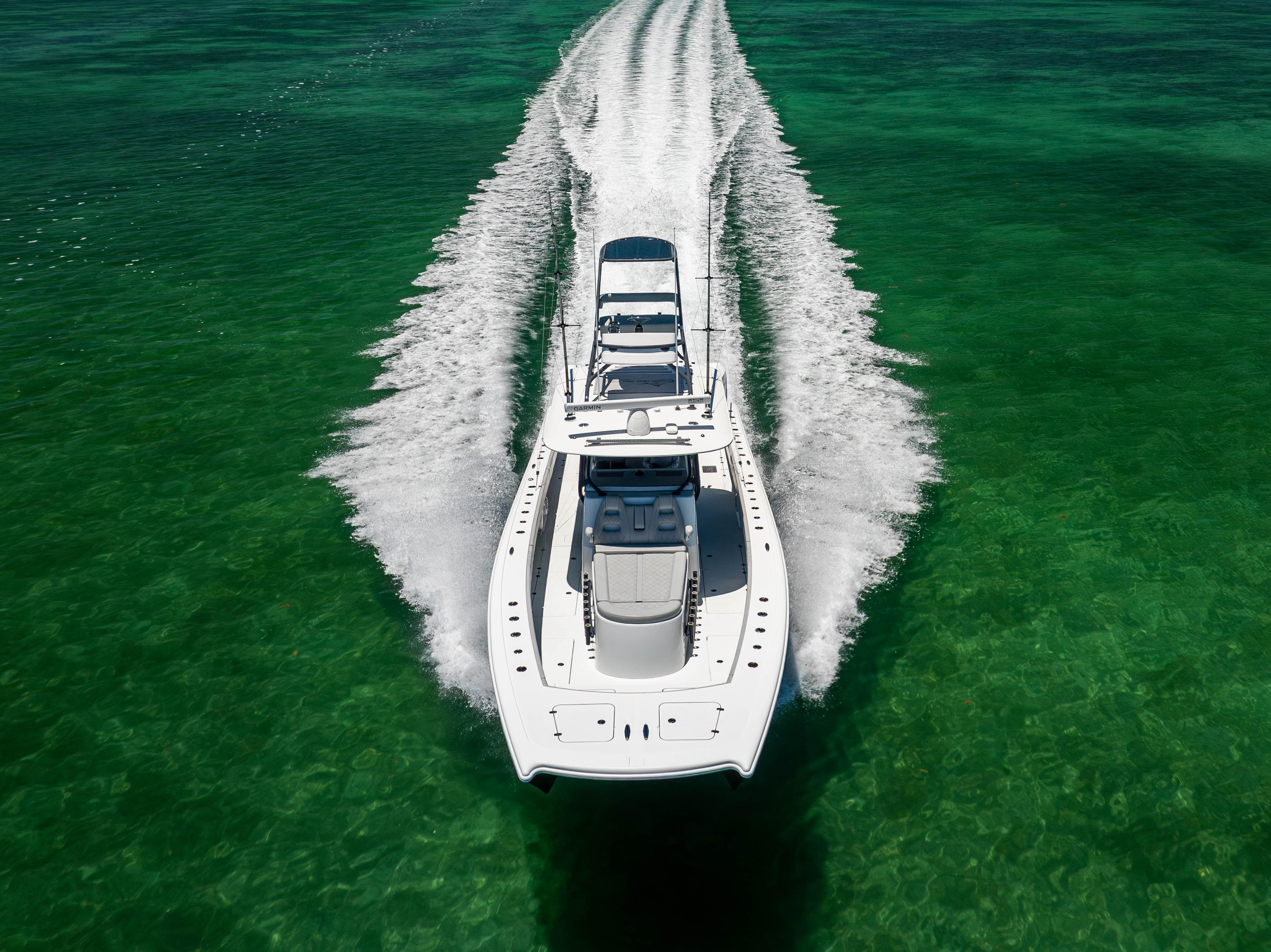 Aerial view of 2021 Freeman 42 LR boat cruising on clear green water.