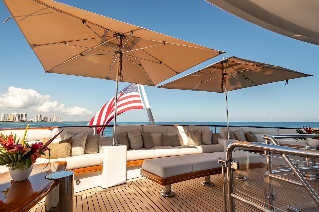 Luxurious 2001 Feadship Custom yacht deck with seating, umbrellas, and ocean view.