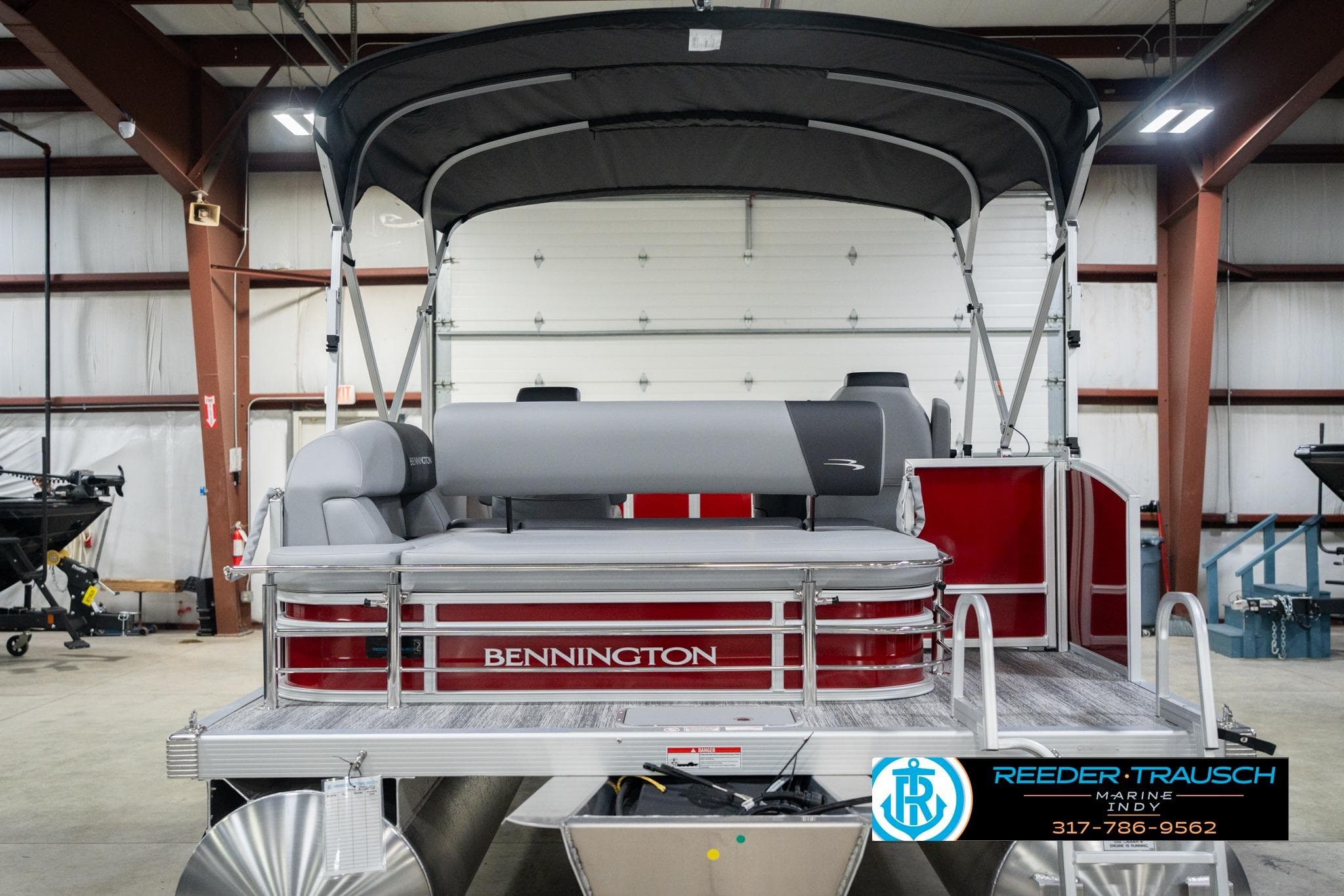 2026 Bennington 20 SSR pontoon boat in a showroom with canopy and seating.