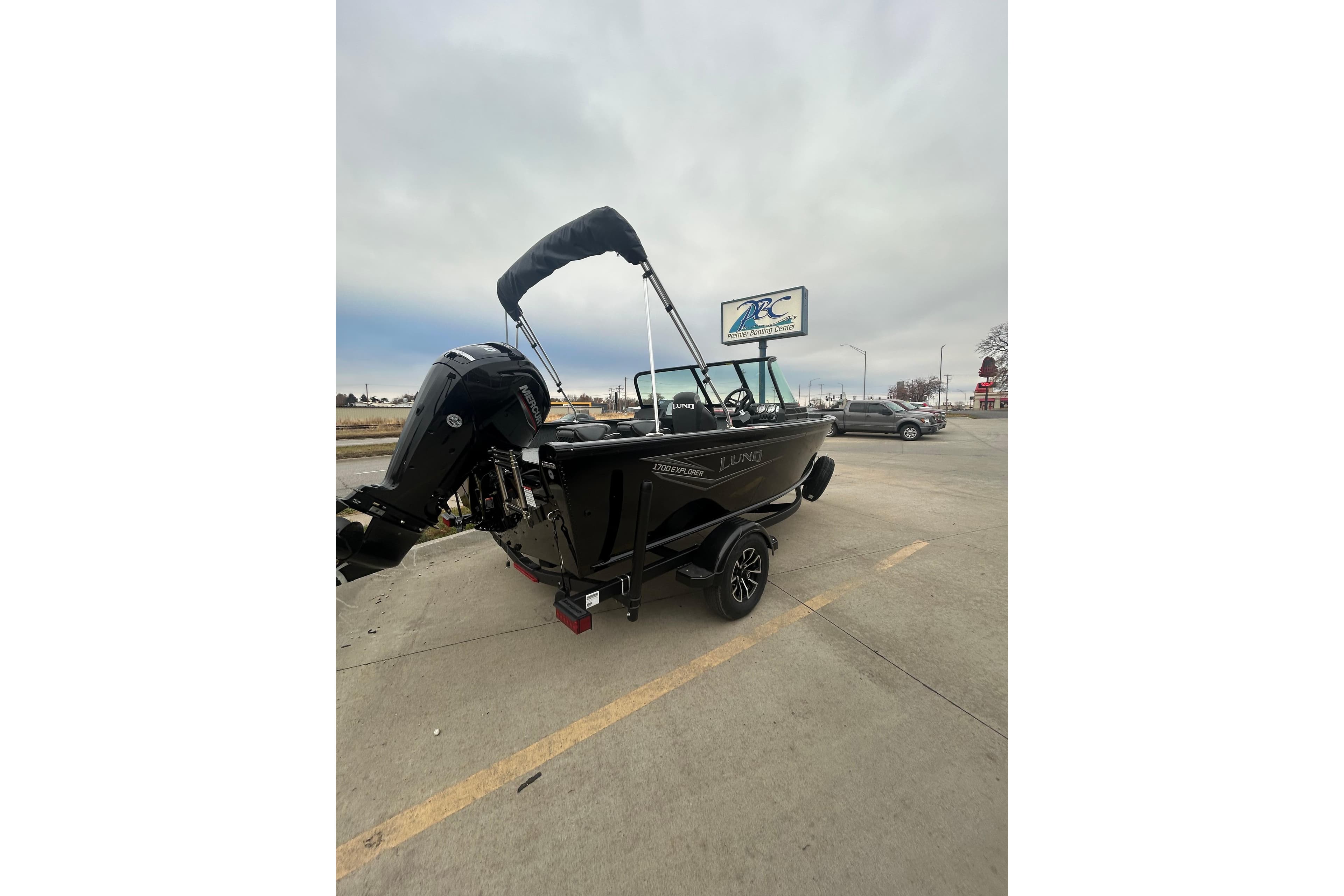 2026 Lund 1700 Explorer Sport boat on trailer in parking lot.