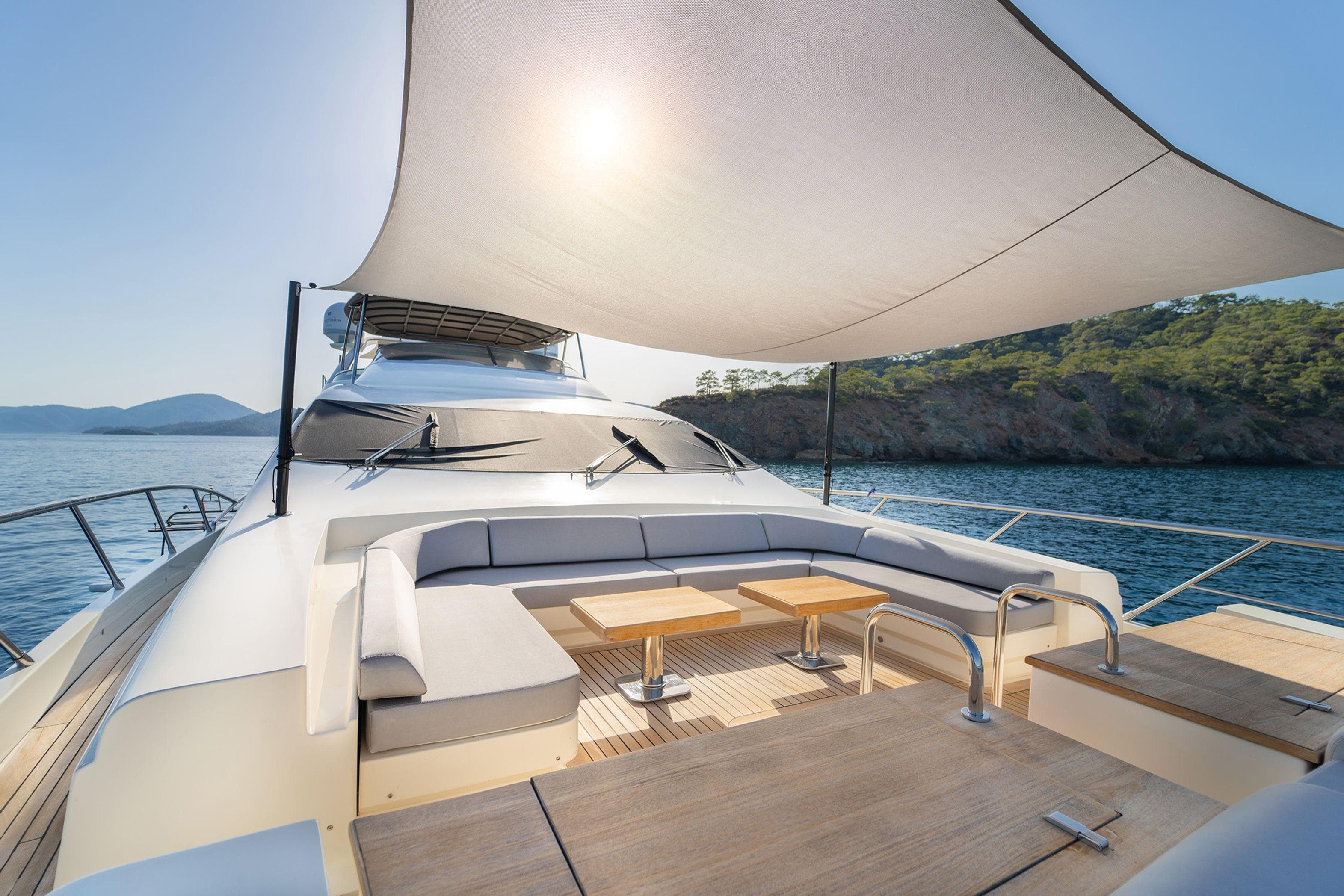 Luxurious 2007 Azimut Leonardo yacht deck with seating, sunshade, and scenic ocean view.