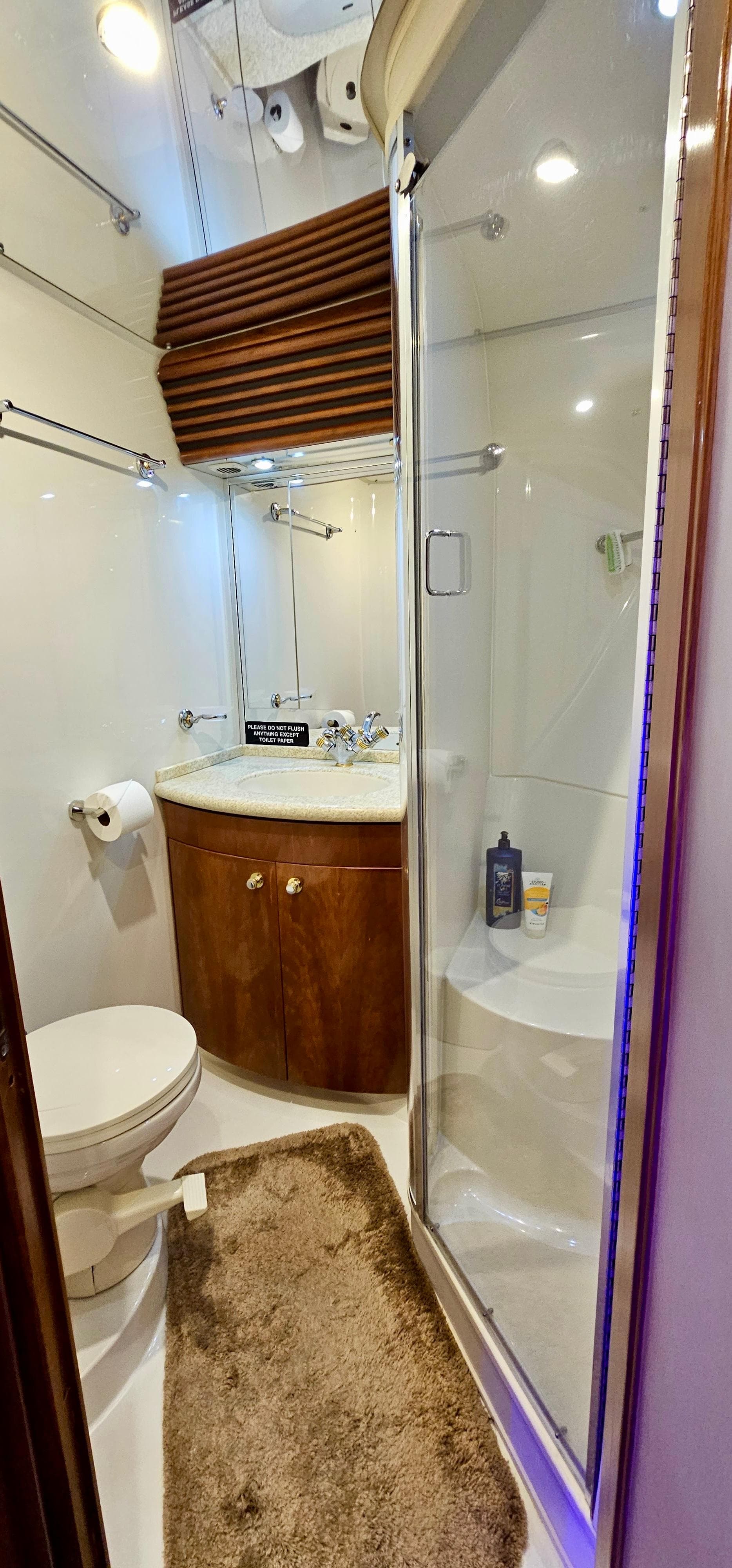 1999 Carver 450 Pilothouse bathroom with shower, sink, and toilet.