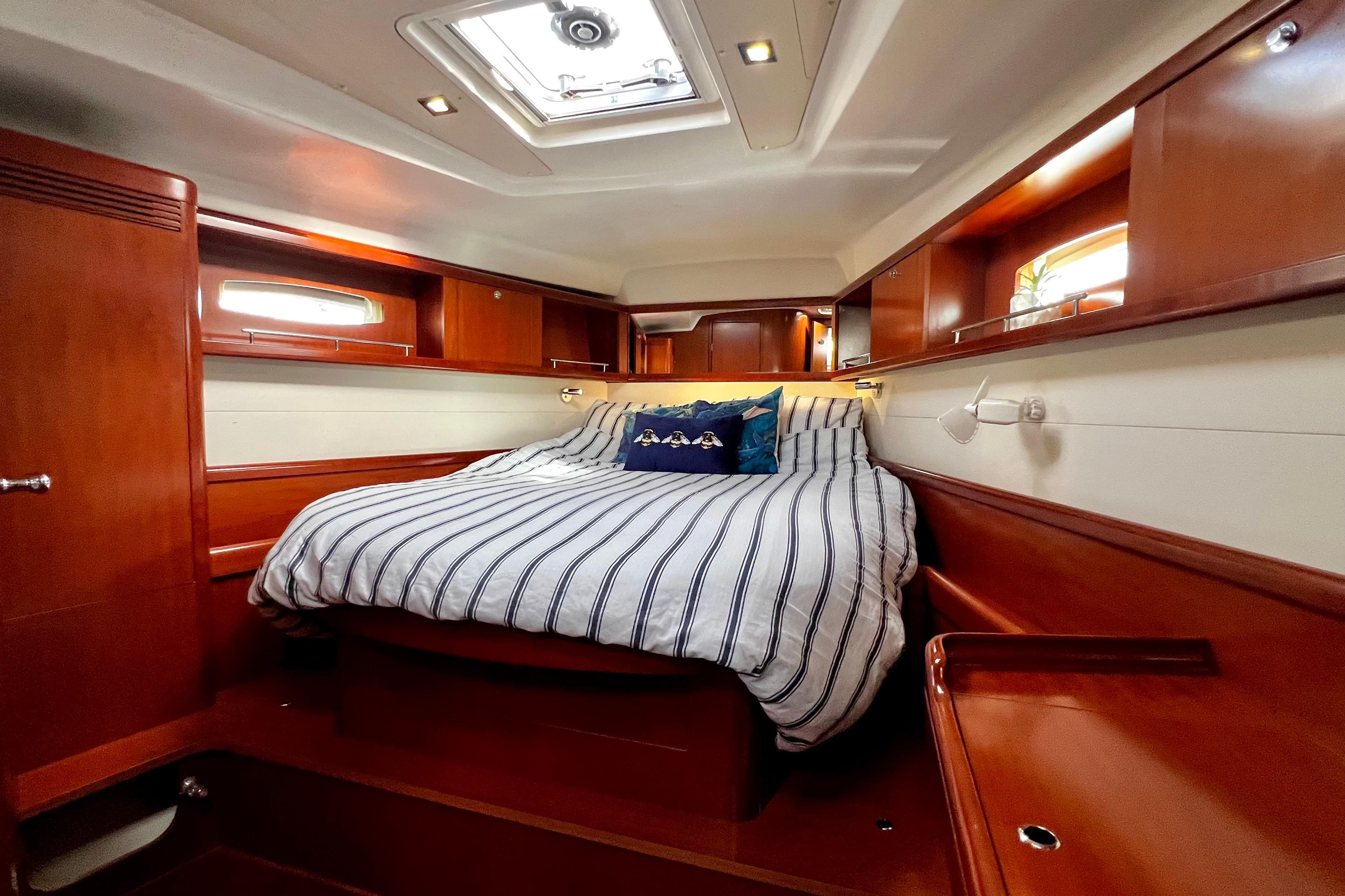 Luxurious cabin interior of 2006 Beneteau Oceanis 50 yacht with striped bedding.
