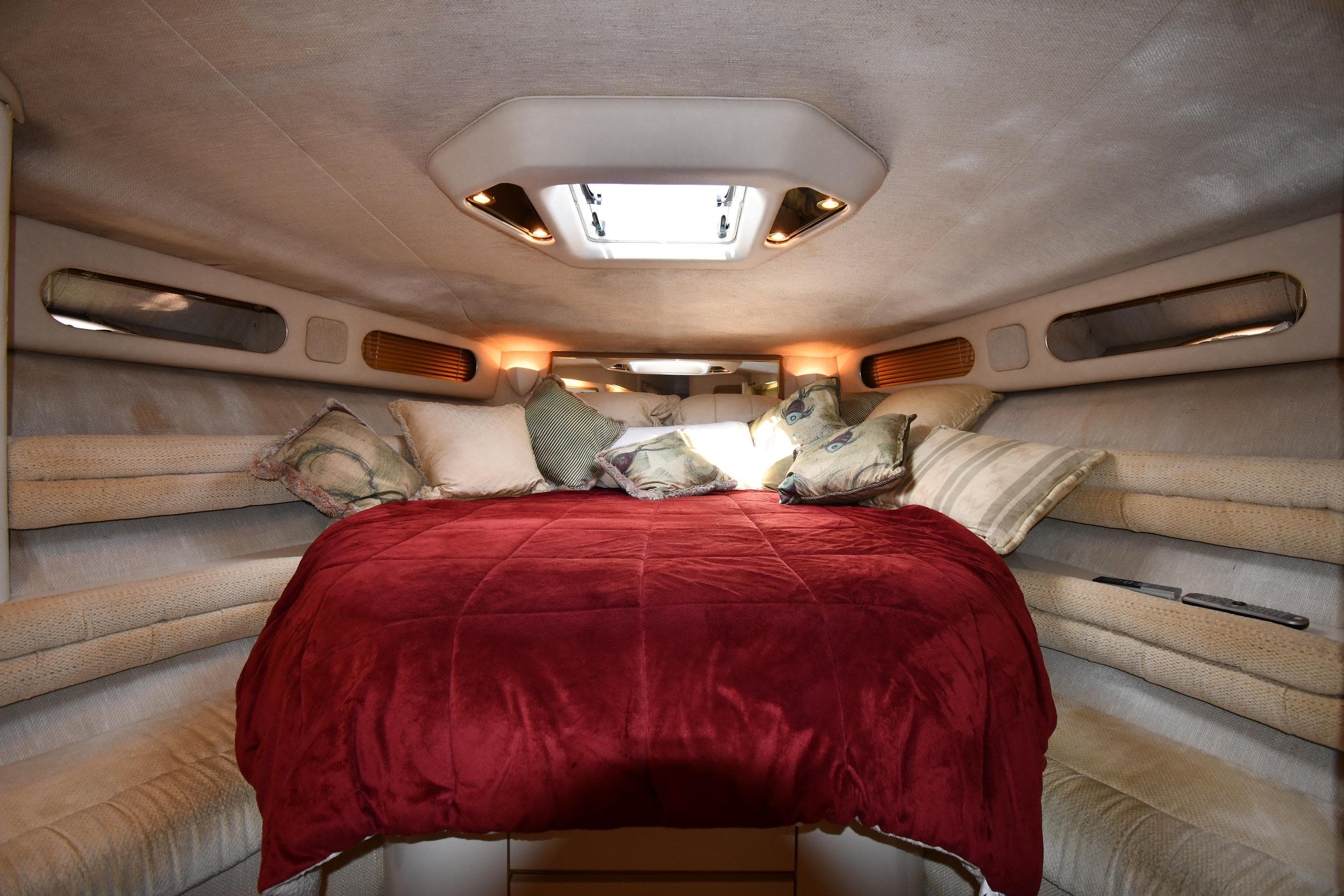 Luxurious cabin interior of 1995 Sea Ray 630 Sundancer with cozy bedding and ambient lighting.