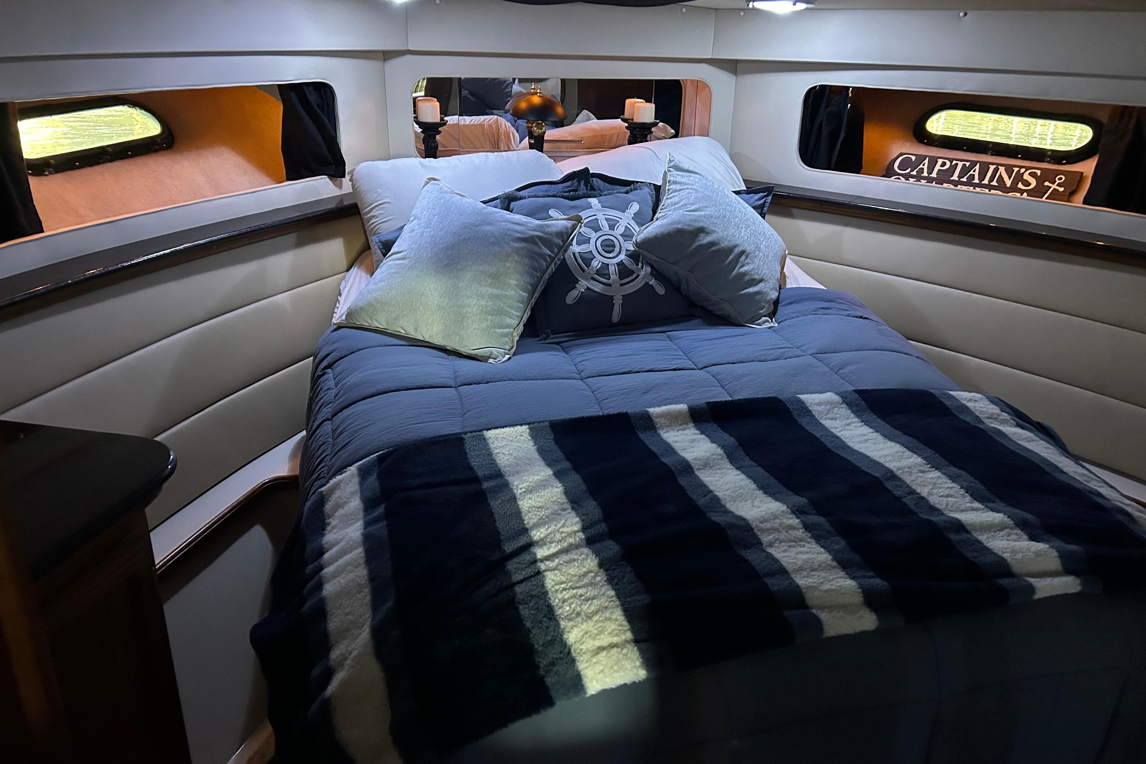 Cozy cabin interior of 1989 Carver 380 Santego with nautical-themed bedding.