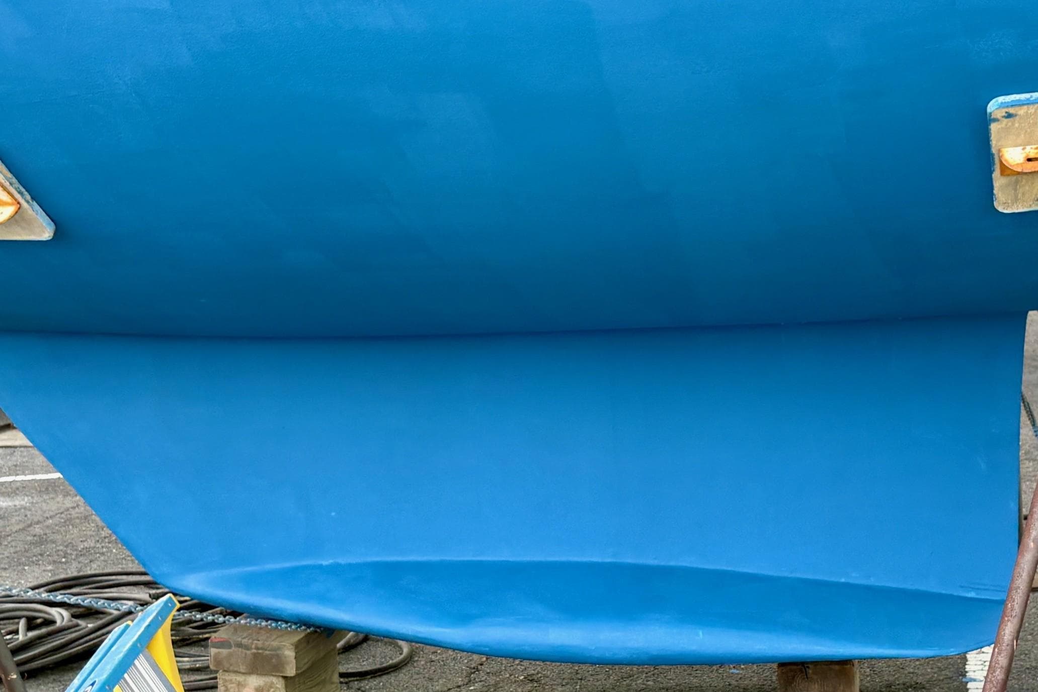 Blue hull of a 1998 Catalina 42 Mk II sailboat on dry dock.