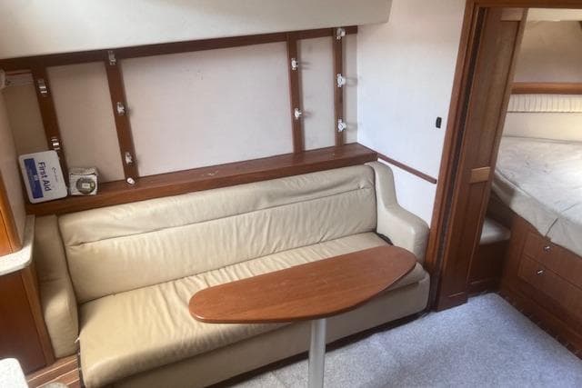 2008 Albemarle 360 Express Fisherman interior with beige sofa and wooden table.