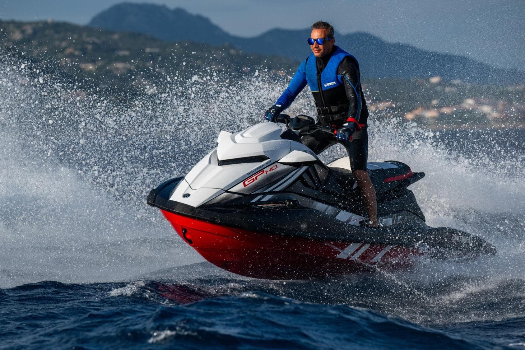 2024 Yamaha WaveRunner GP1800R SVHO jet ski speeding on water, rider in blue vest.