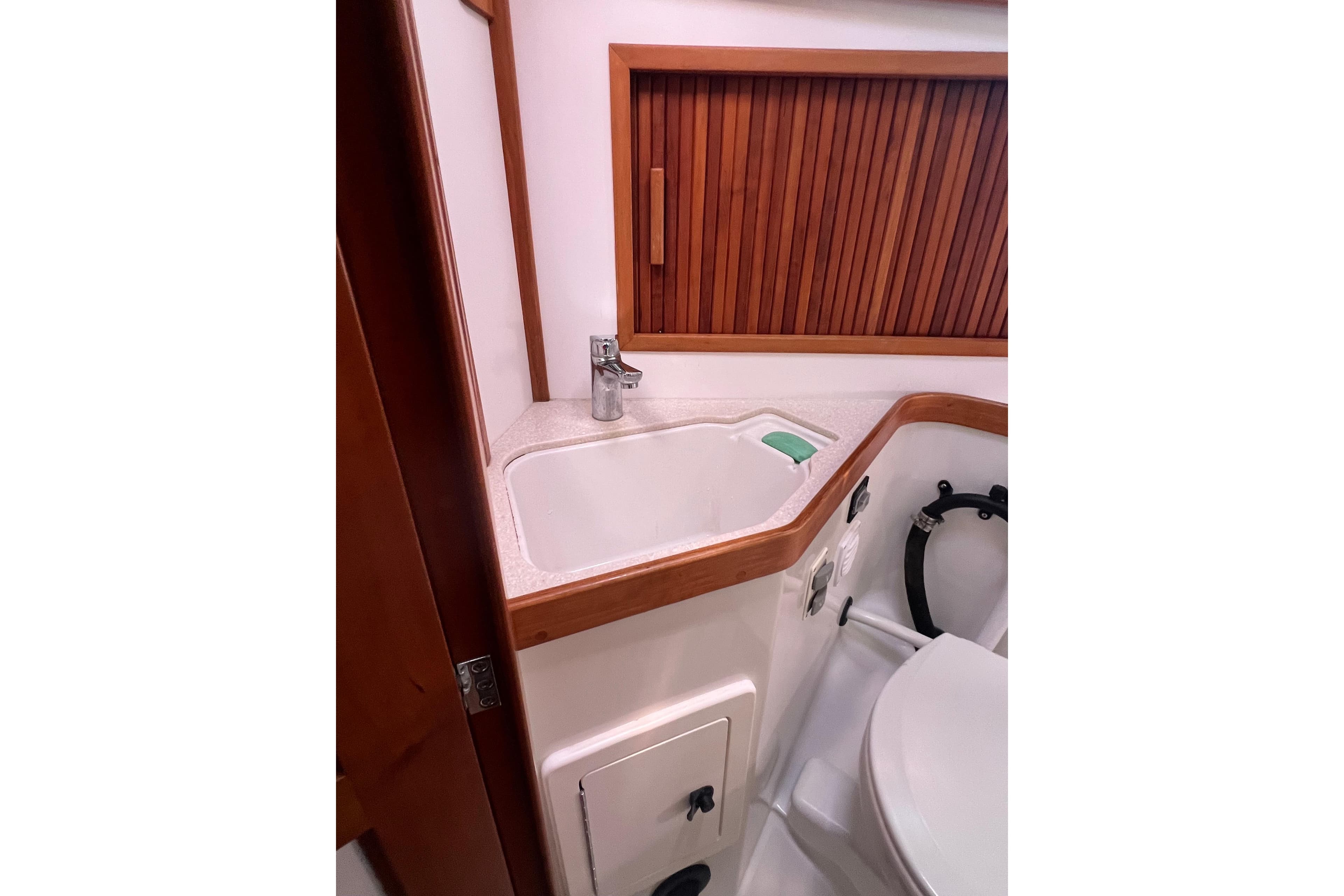 2005 Sabre Flybridge bathroom with sink, wooden accents, and modern fixtures.