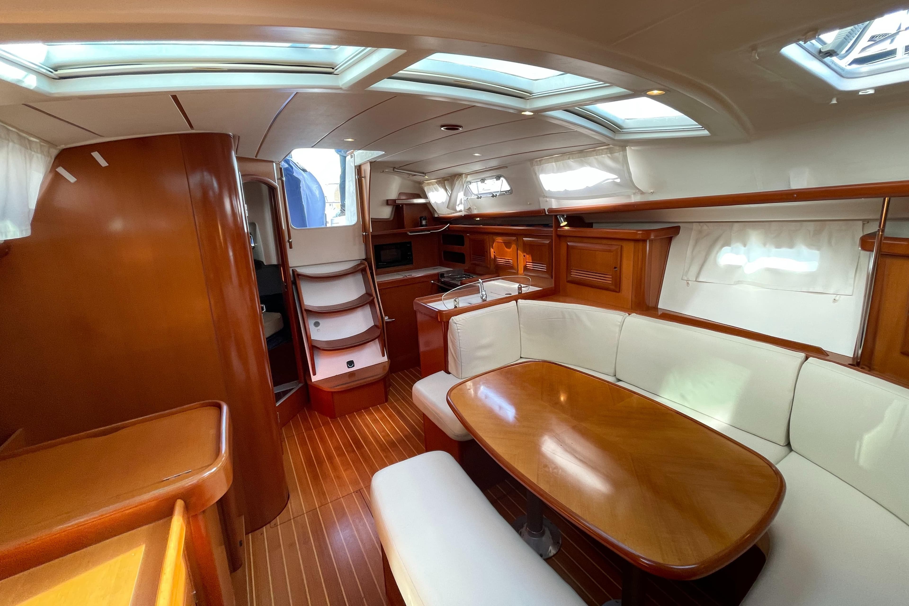 Interior of 2006 Beneteau 393 yacht with wood finish and white seating.