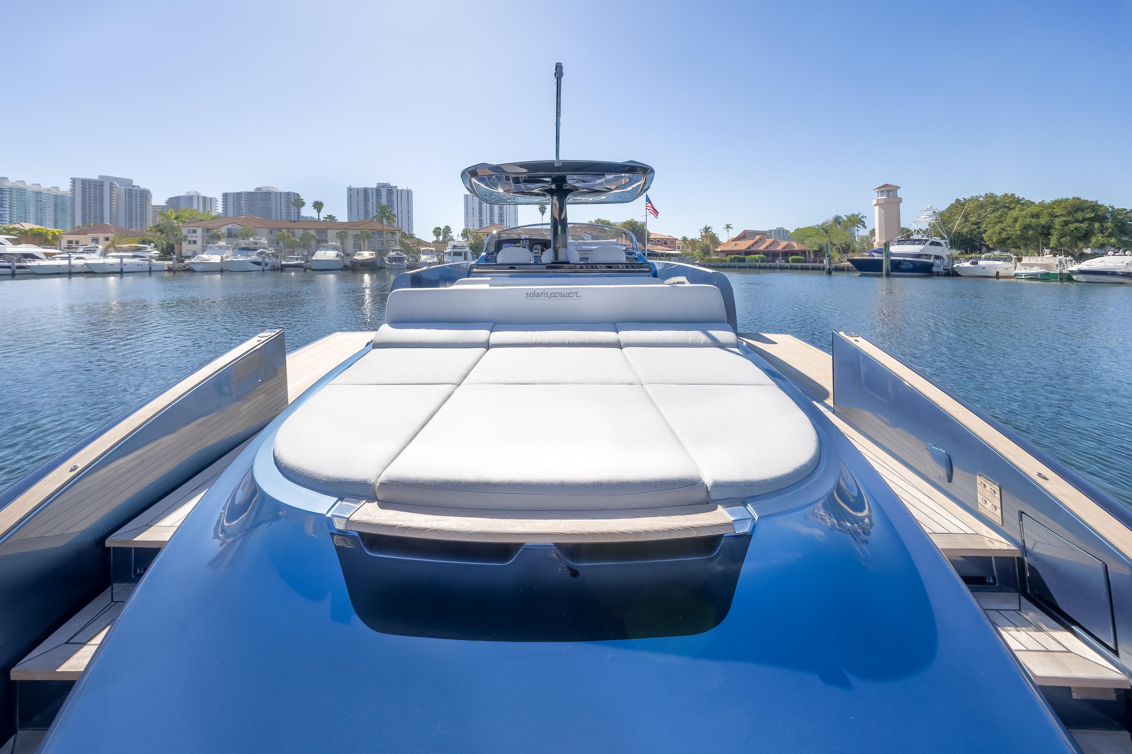 2021 Solaris Power 48 OPEN yacht docked in a marina under clear blue skies.