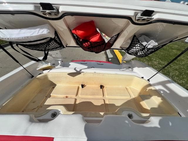 Open storage compartment of a 2004 Yamaha Boats AR 210 with safety gear.