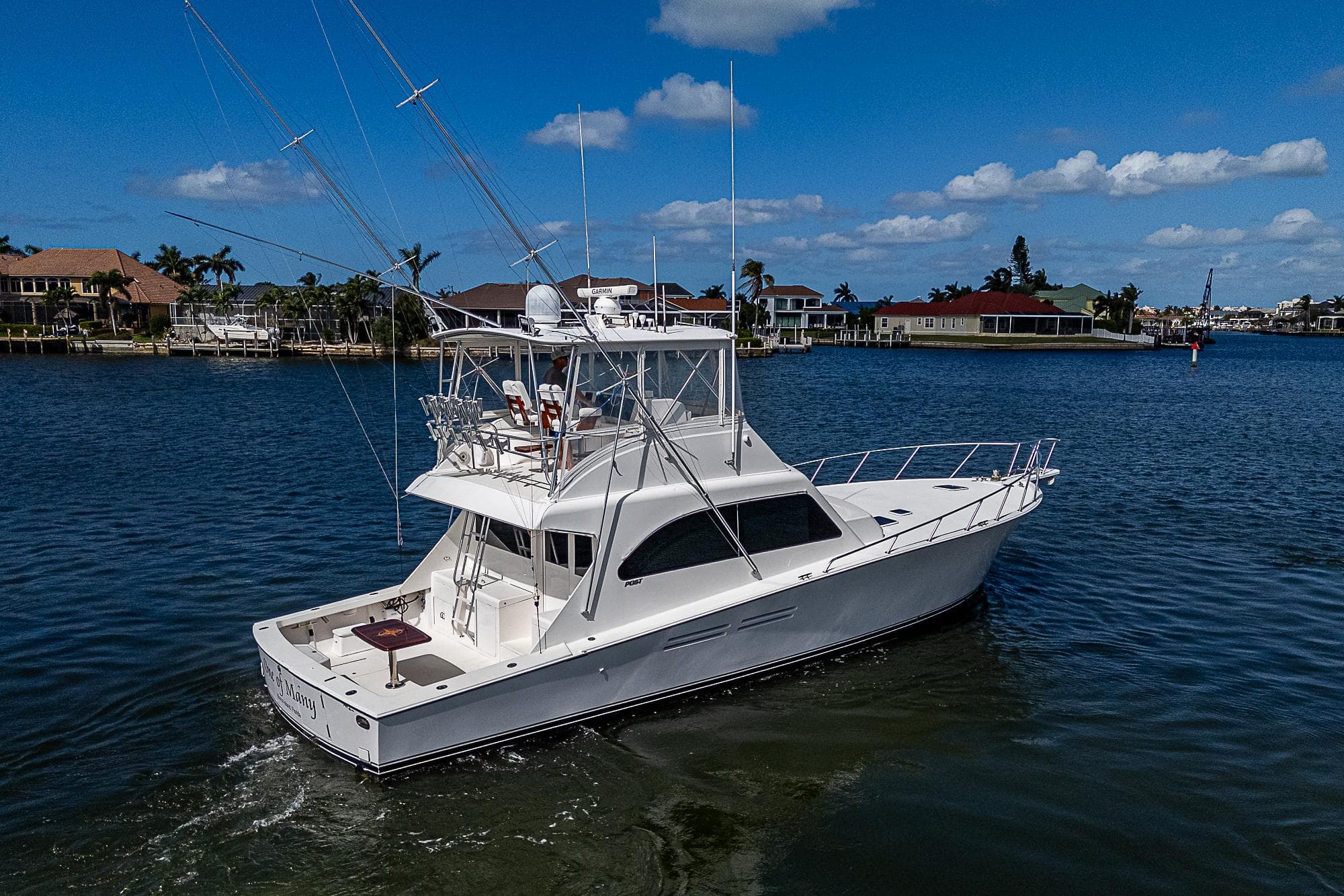 1999 Post 50 Convertible yacht cruising on a sunny day in a coastal area.