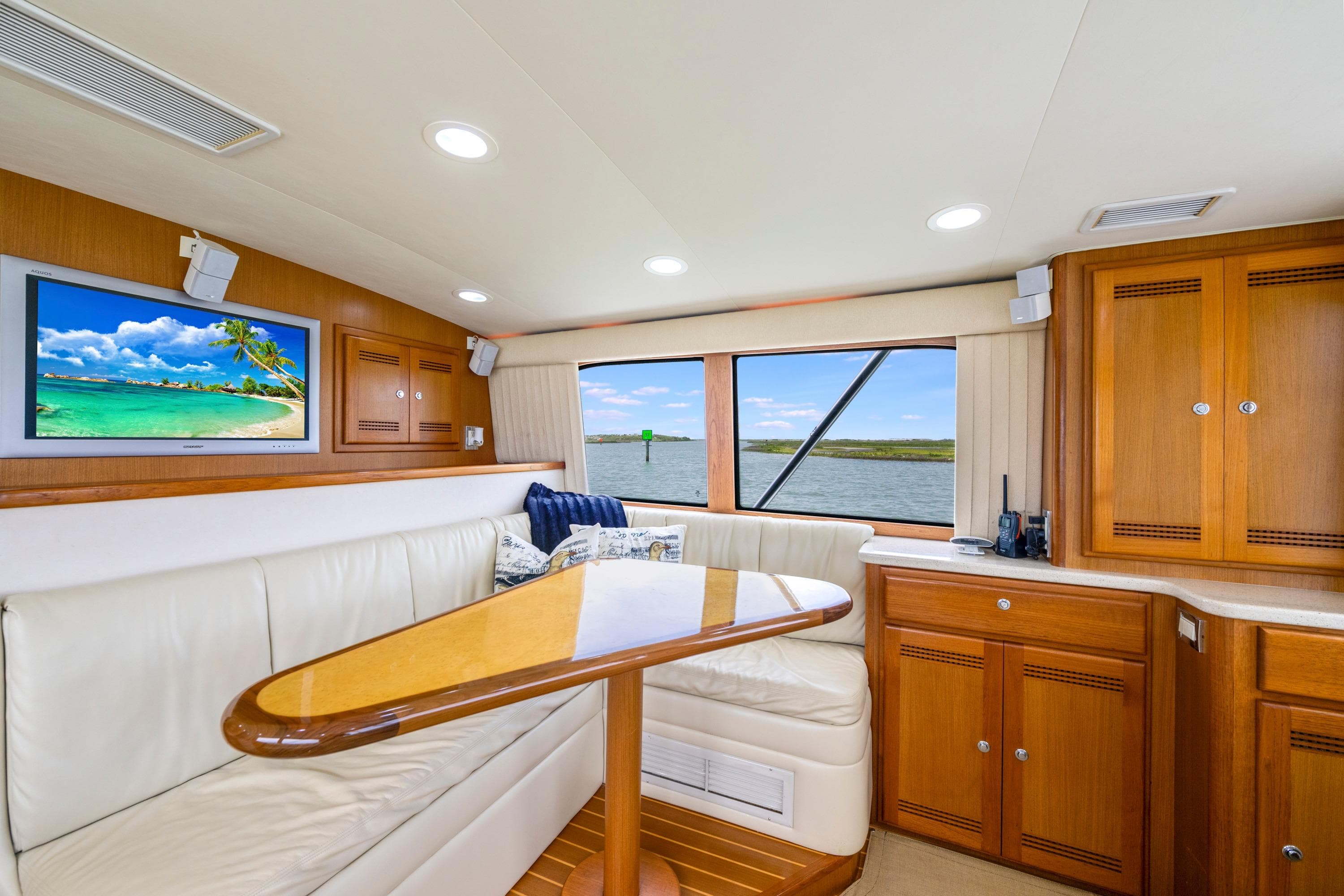Luxurious interior of 2005 Cabo 40 Flybridge yacht with elegant seating and scenic window view.
