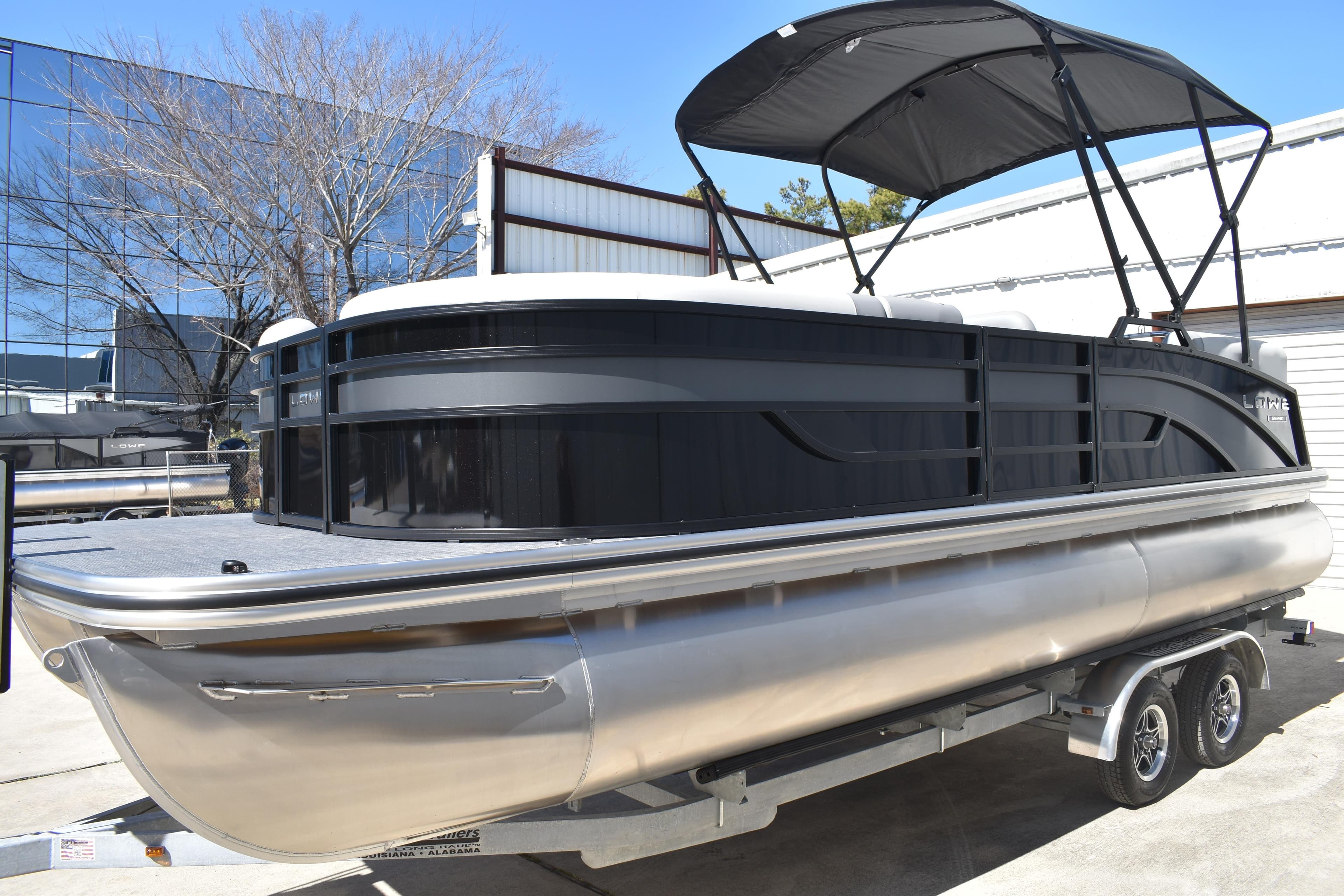 2026 Lowe SS 230 WT pontoon boat with canopy on trailer, parked outdoors.