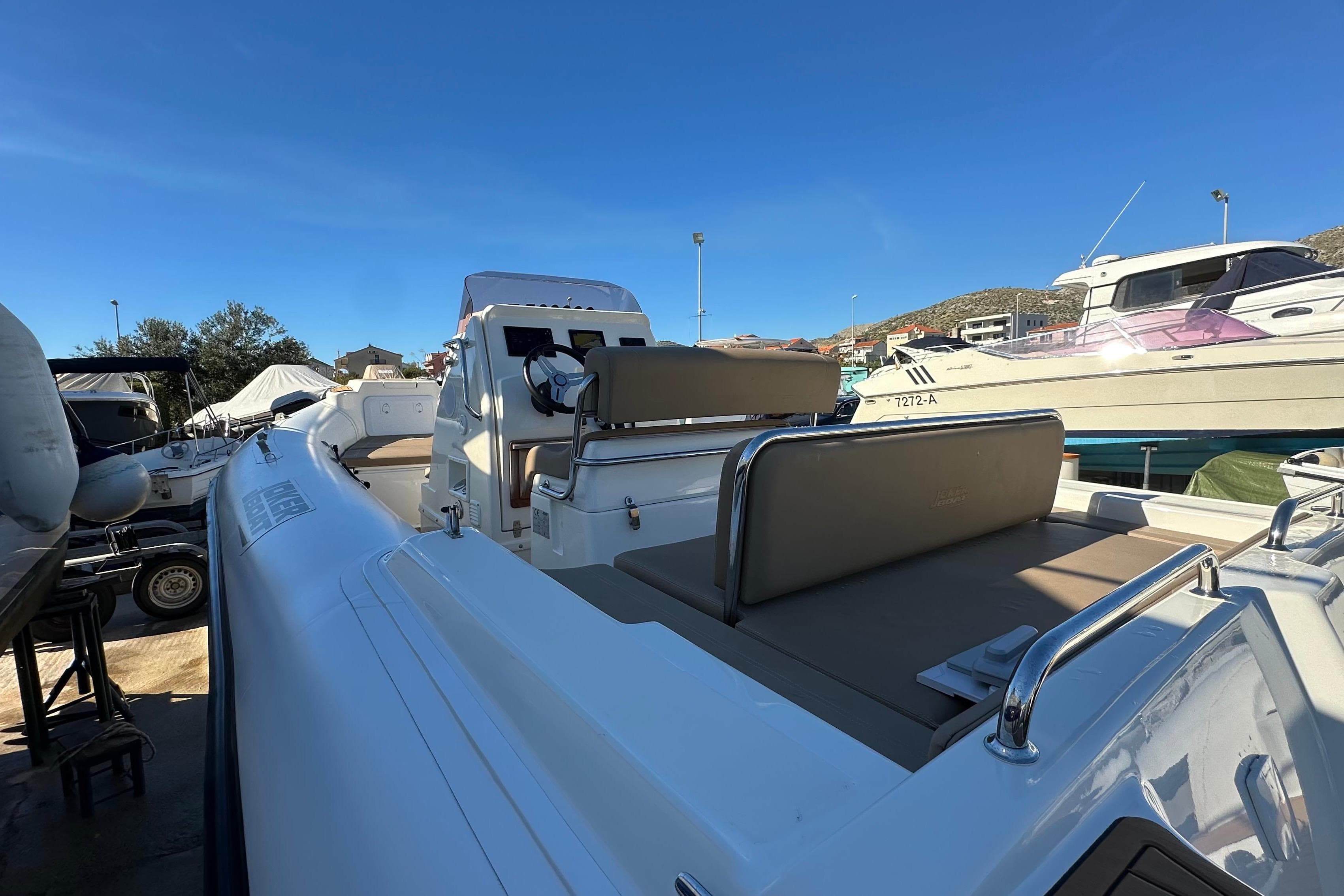 2023 Joker Boat Clubman 26, sleek design, docked with other boats under clear blue sky.