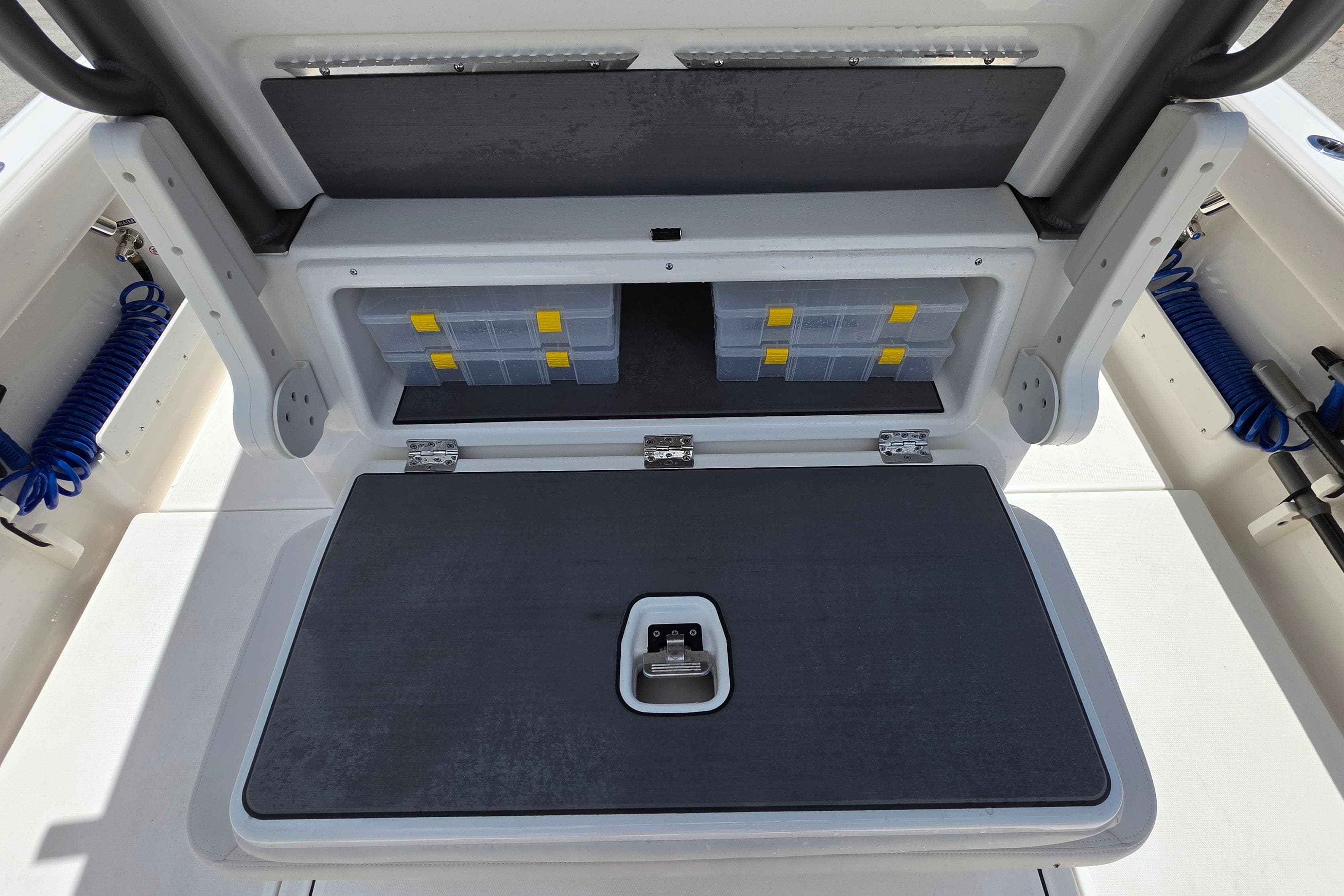 Storage compartment on a 2026 Solace 28HCS boat, featuring organized tackle boxes.