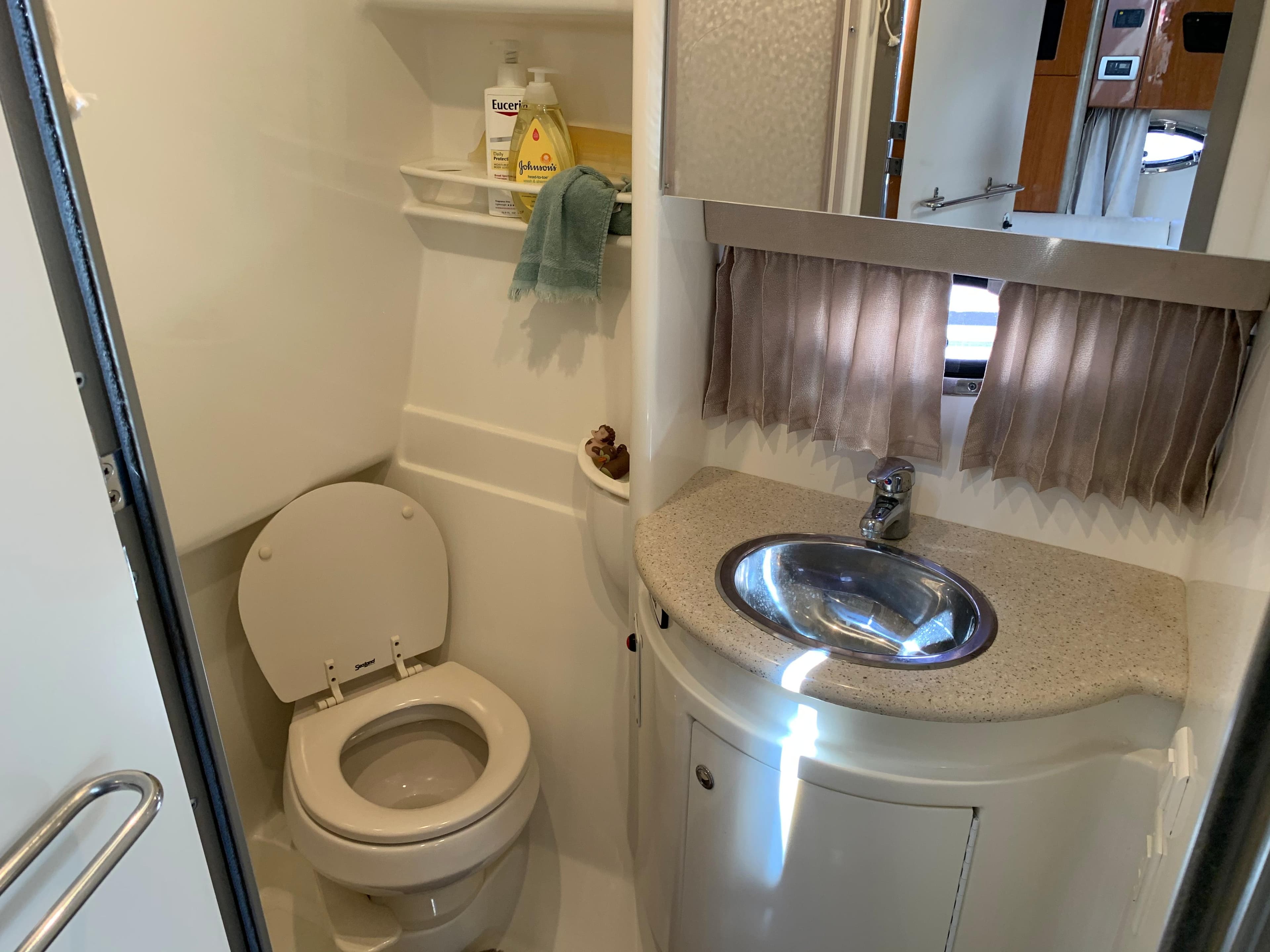 2005 Formula 34 Performance Cruiser bathroom with toilet, sink, and storage shelves.