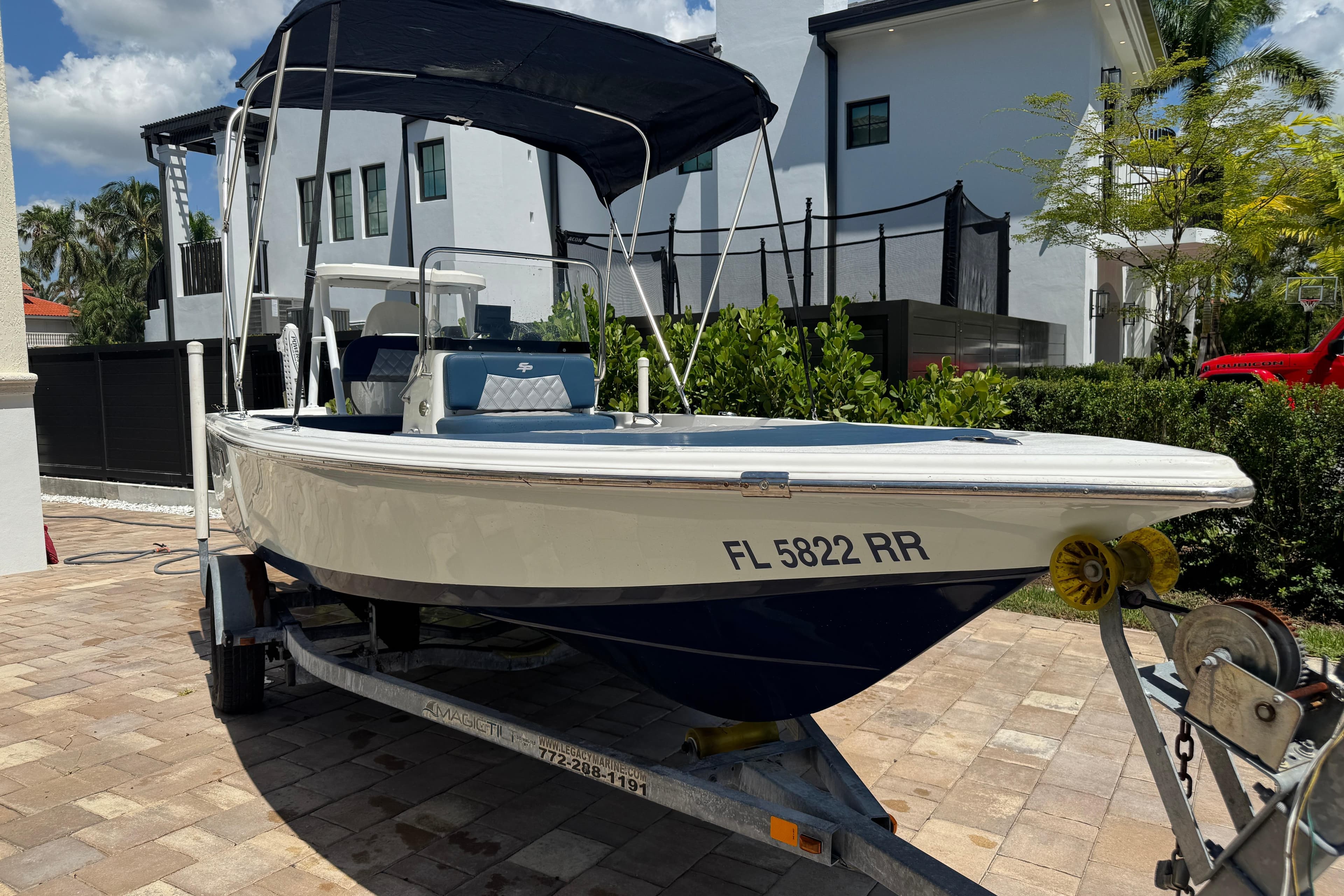 2019 Sea Pro 172 Bay boat on trailer, parked in a residential driveway.