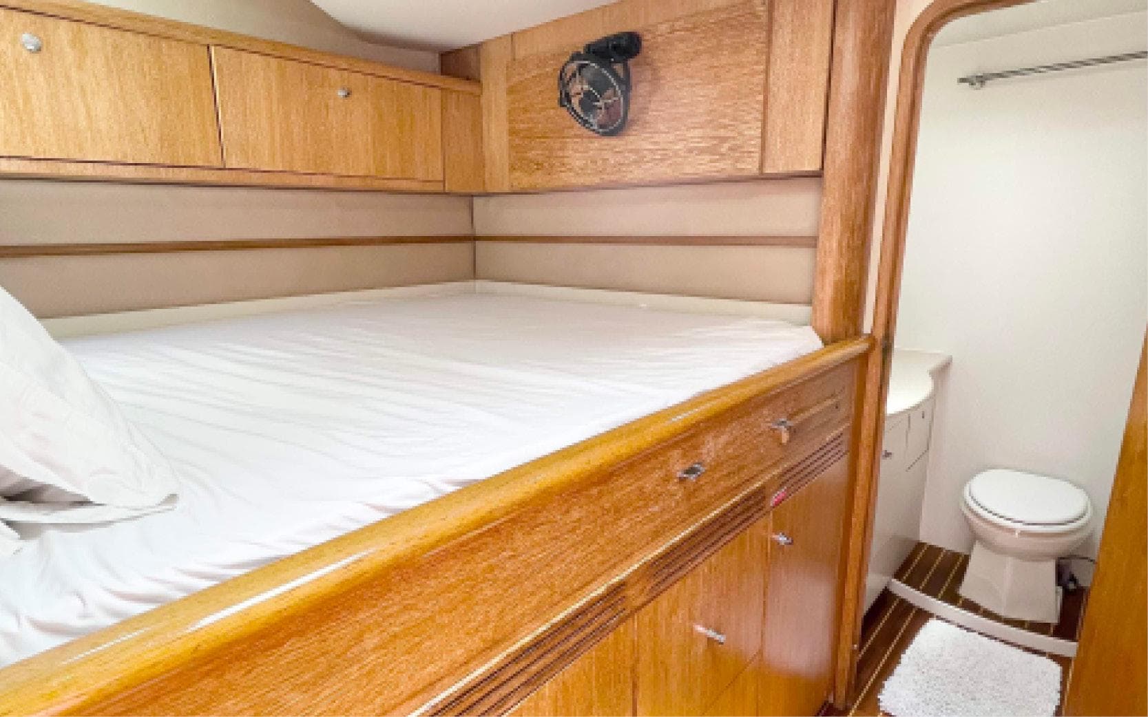Luxurious cabin interior of 1996 Privilege 65 yacht with bed and ensuite bathroom.