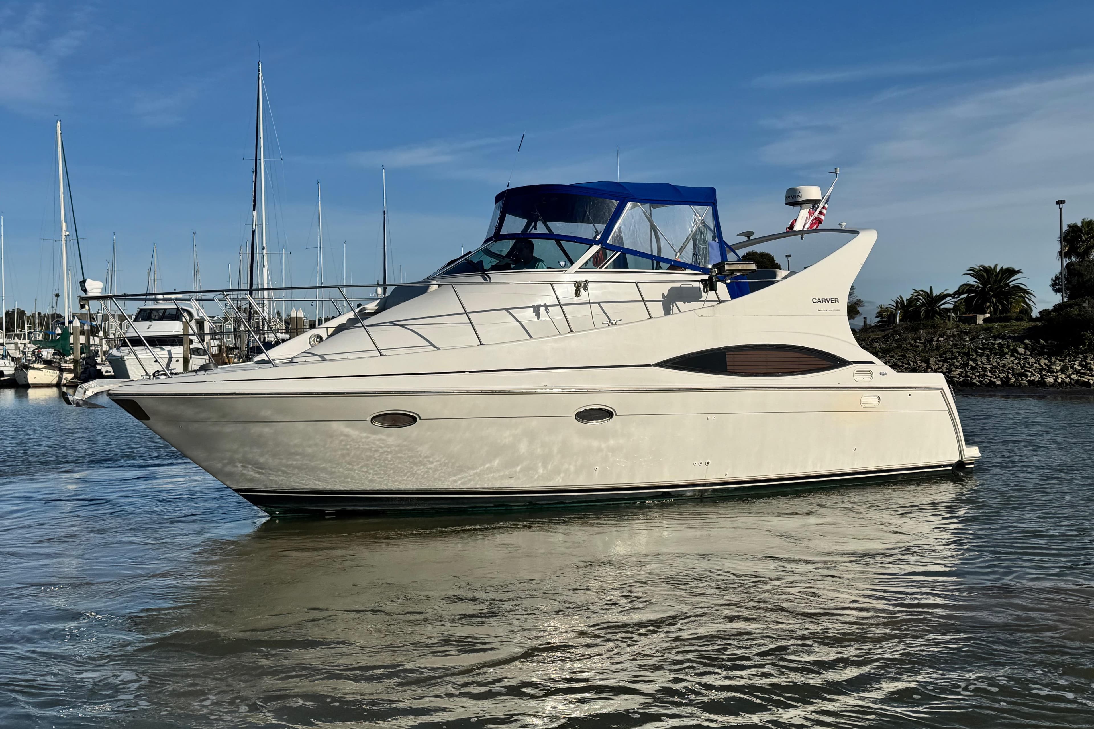 1997 Carver 350 Mariner yacht docked in a marina under clear blue skies.