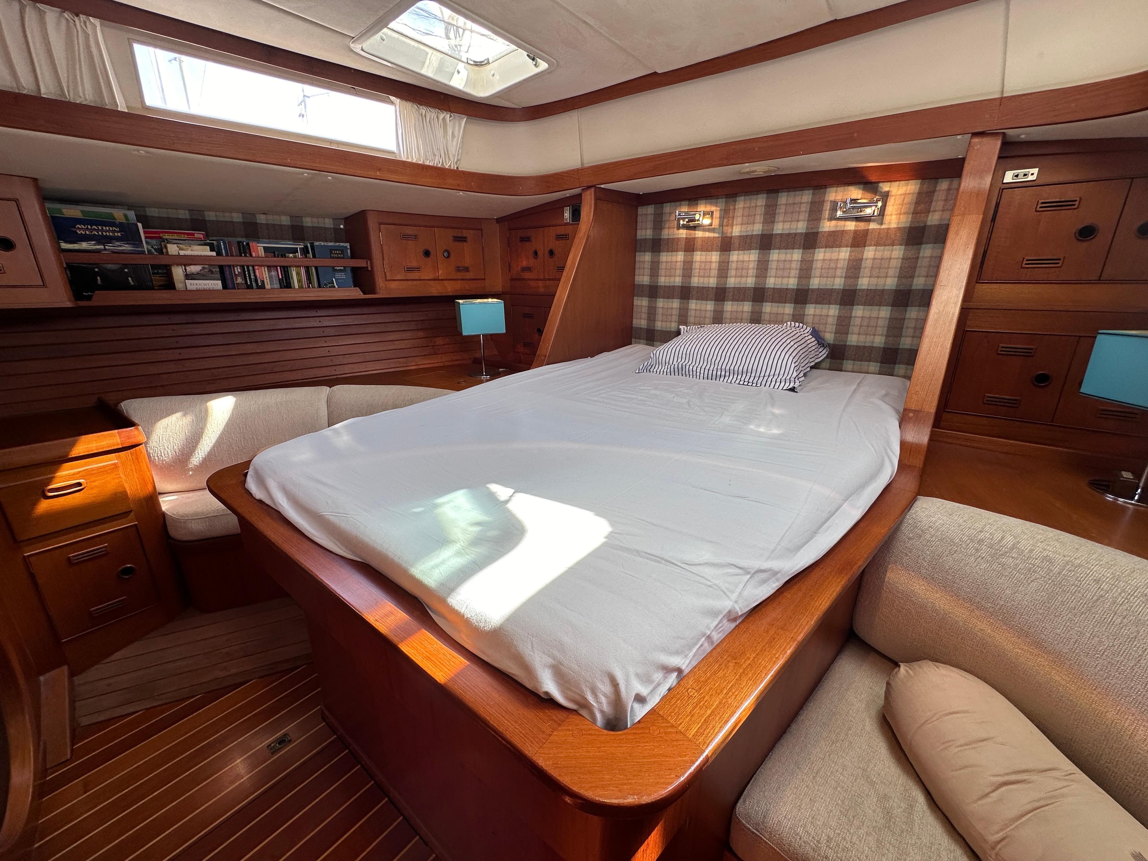 Luxurious cabin interior of a 1987 Standfast 50 yacht with cozy bed and wooden furnishings.