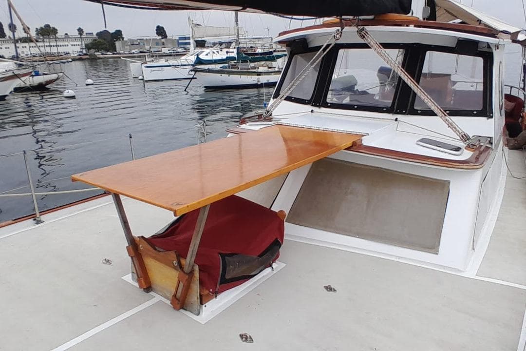 1974 Force Hudson 50 yacht with wooden deck table, docked in marina.