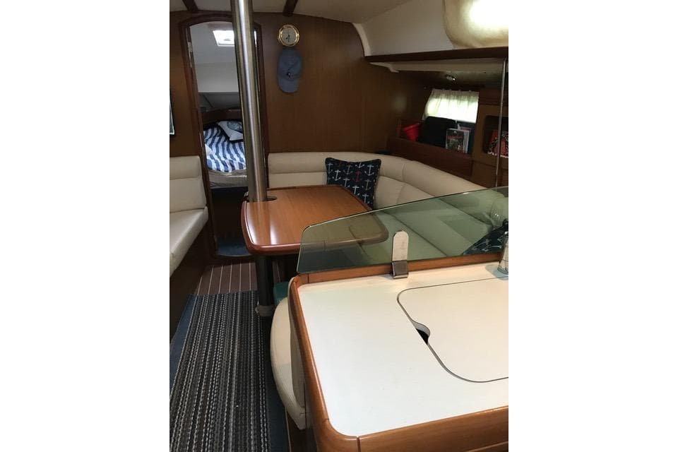 Interior of 2007 Jeanneau Sun Odyssey 36i sailboat with cozy seating and dining area.