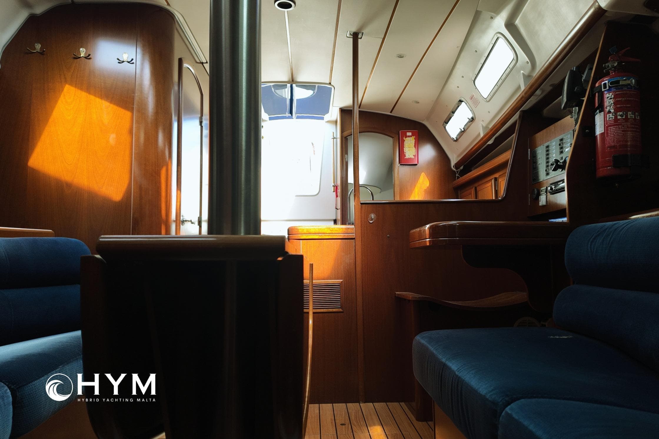 Interior of 2005 Beneteau Oceanis Clipper 373 yacht with wooden finish and blue seating.