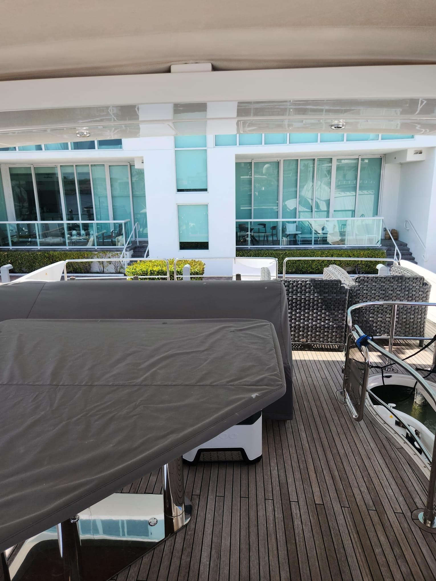 Azimut Flybridge 2014 yacht deck with covered seating and modern architecture in the background.