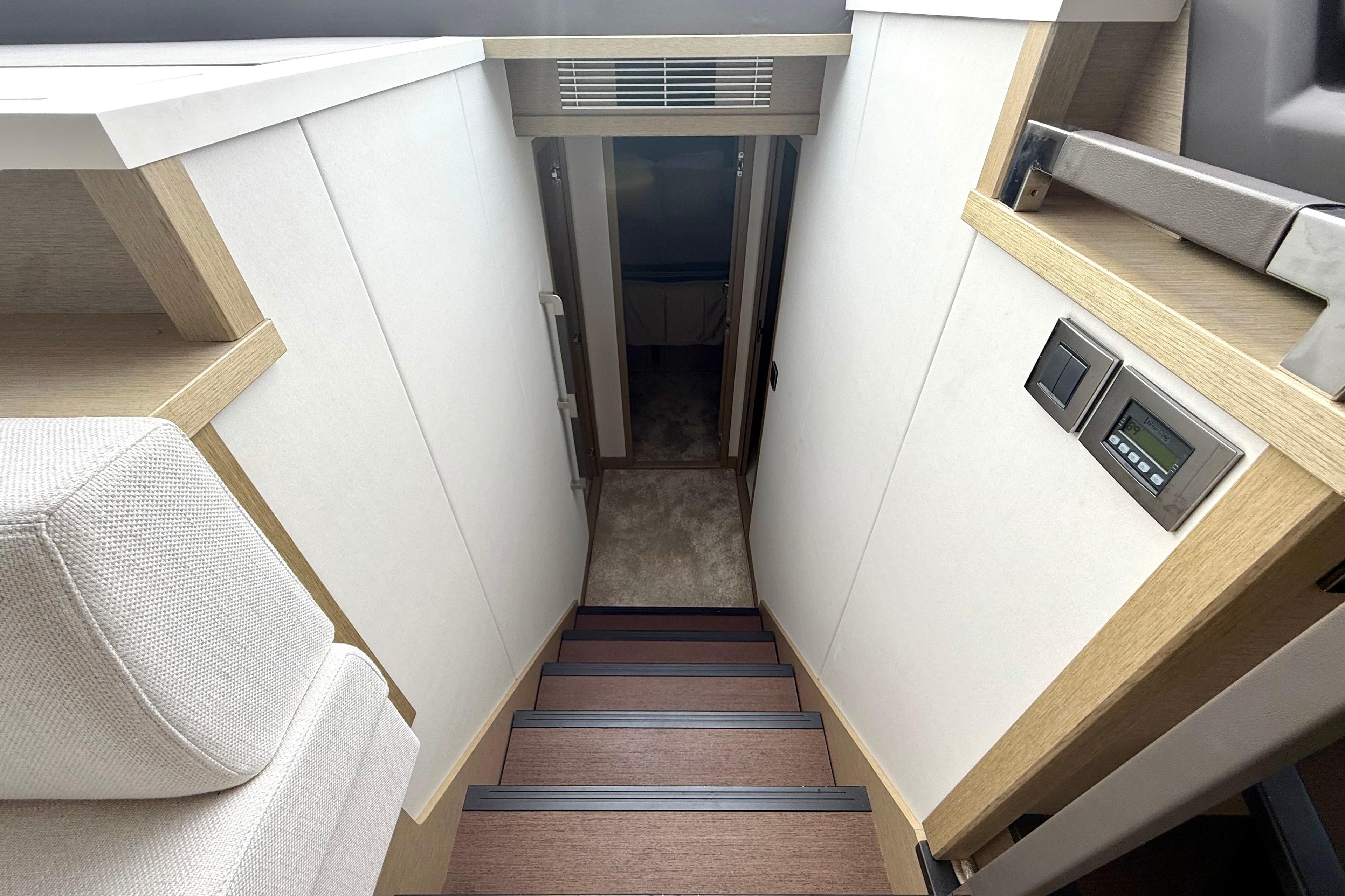 Staircase in 2020 Prestige 590 yacht interior with modern design and control panel.