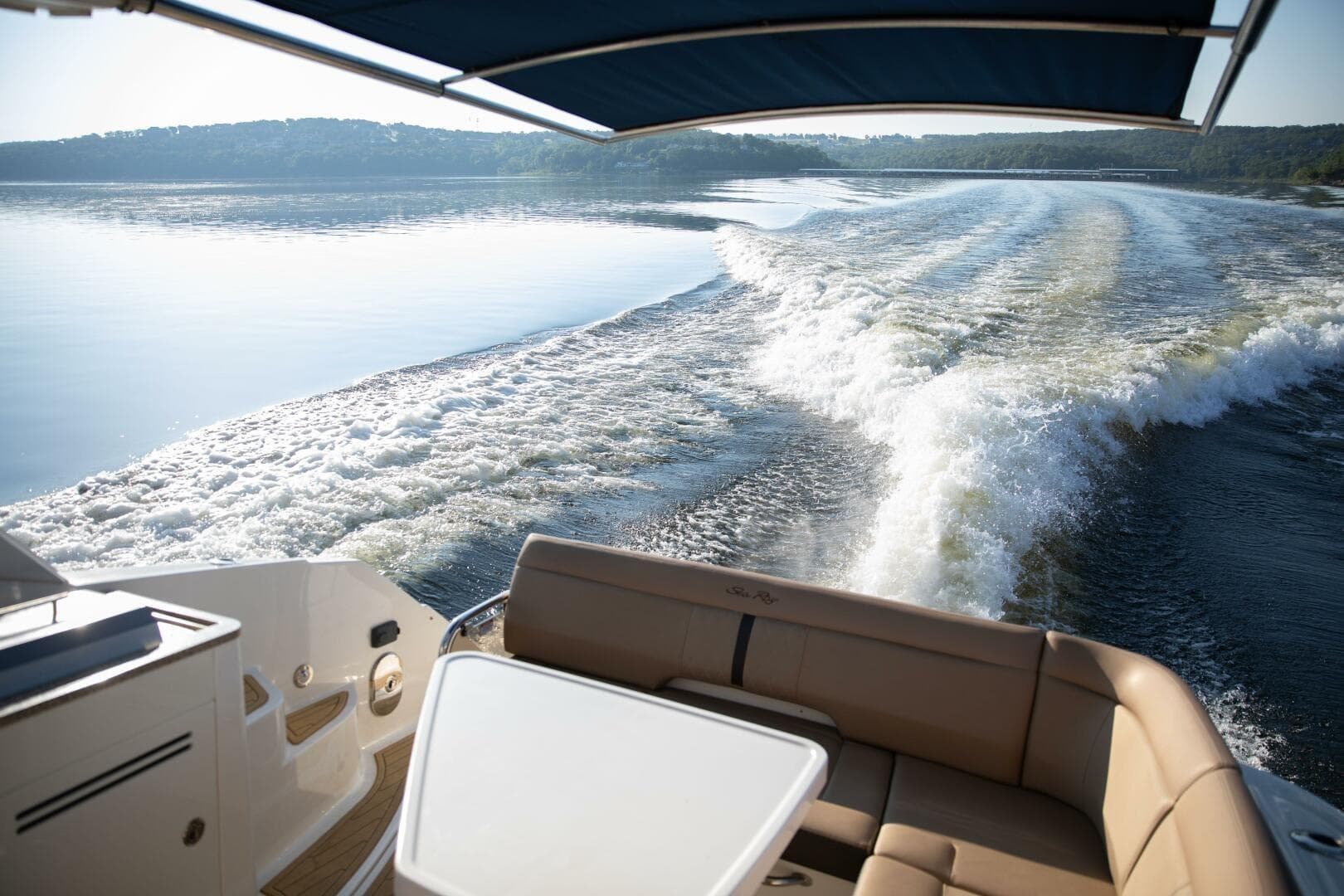 2016 Sea Ray 350 Sundancer cruising on a serene lake, leaving a wake behind.