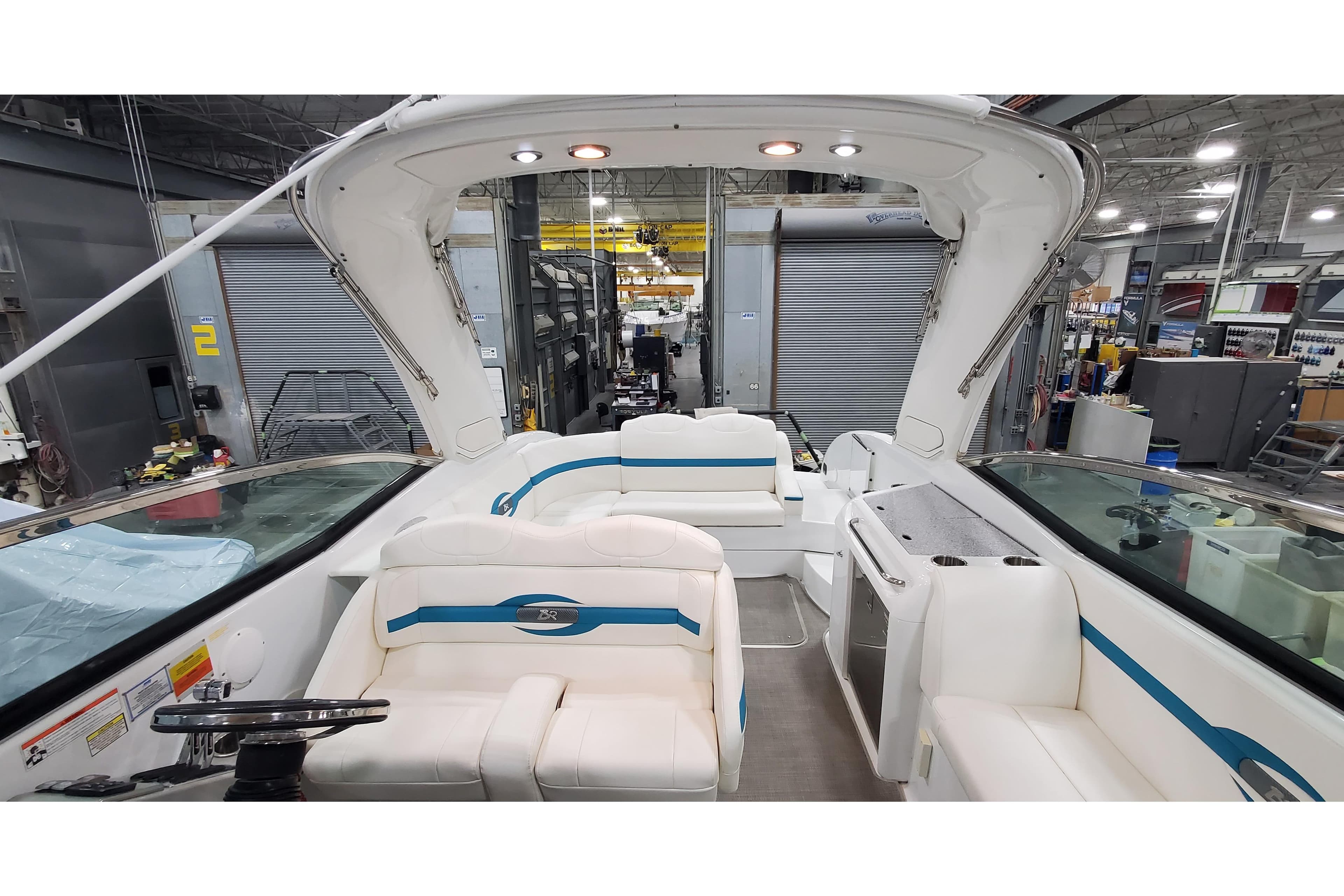 2009 Formula 310 Bowrider interior with white seating and modern amenities in a workshop setting.