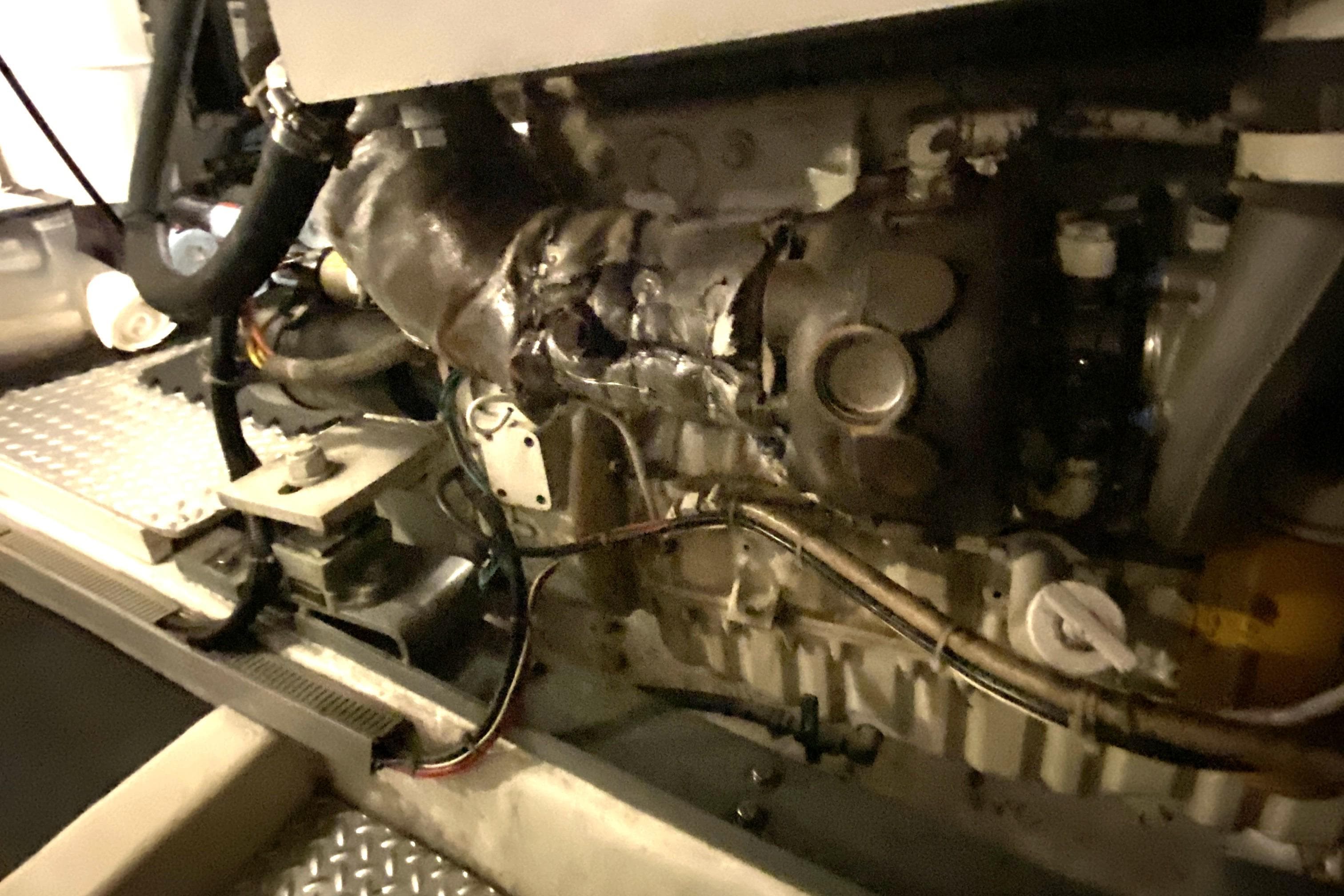 Engine compartment of a 2000 Compass 55, showing mechanical components and wiring.