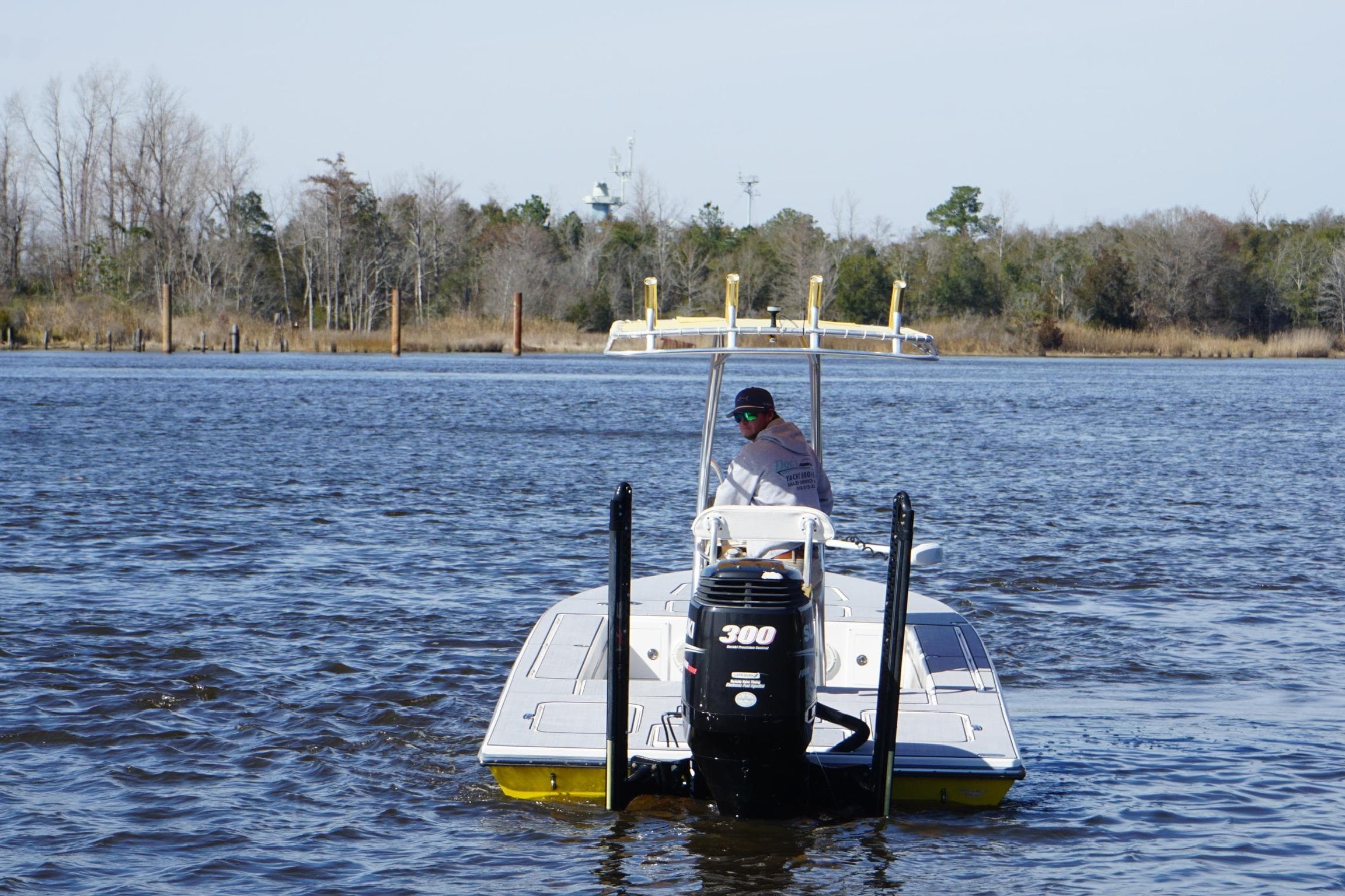 2008 Release Tarpon Bay boat on a calm river with trees in the background.