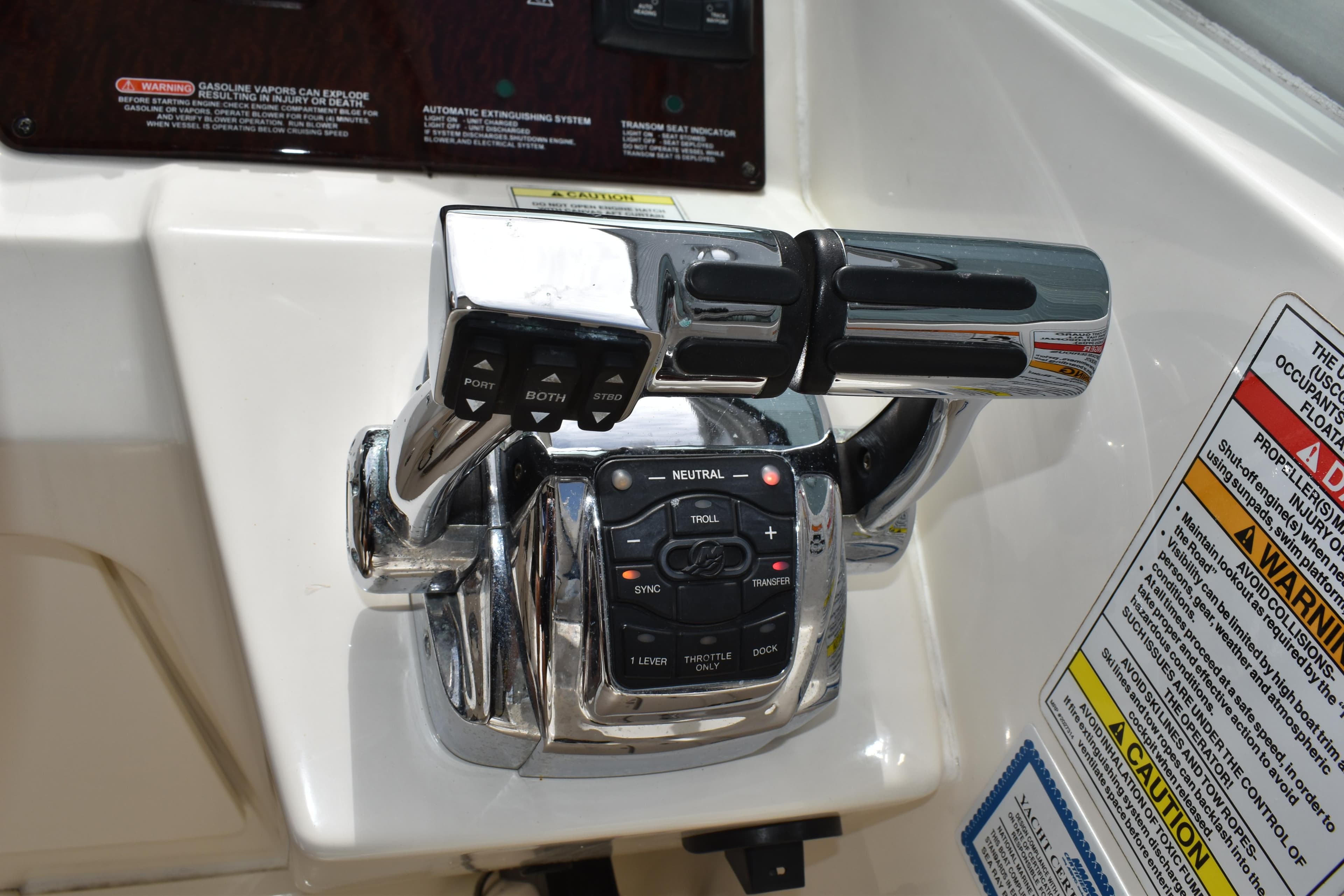 Throttle controls on a 2011 Sea Ray 310 Sundancer boat dashboard with warning labels.