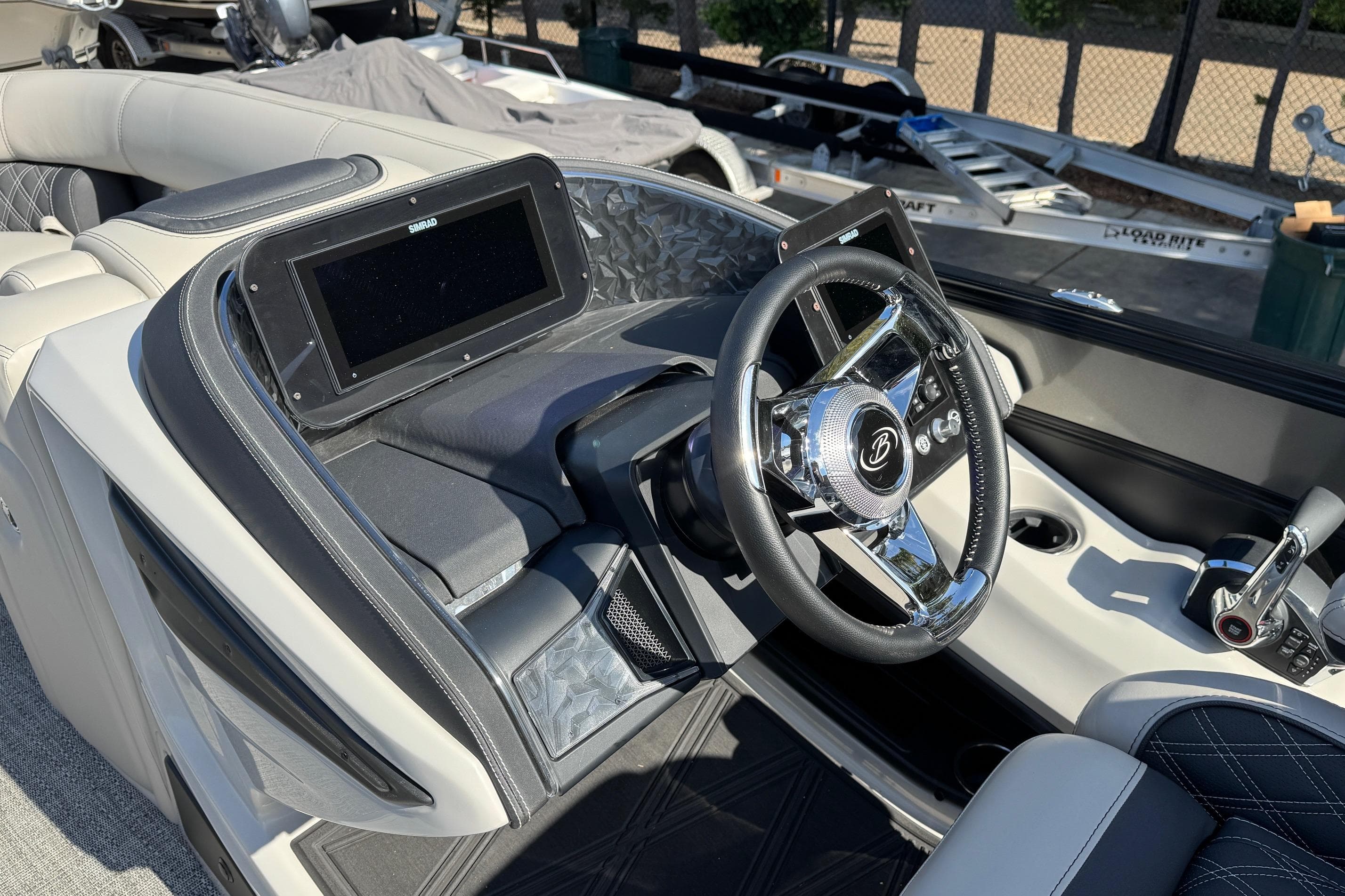 2026 Barletta Lusso 23UC boat dashboard with steering wheel and navigation display.