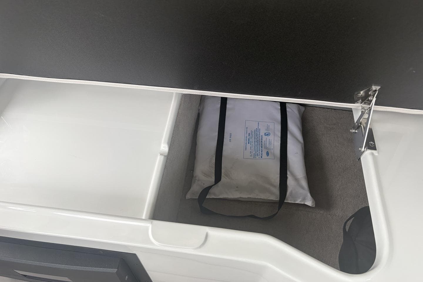 Storage compartment in a 2018 Crownline Eclipse E30 boat, featuring a life jacket.