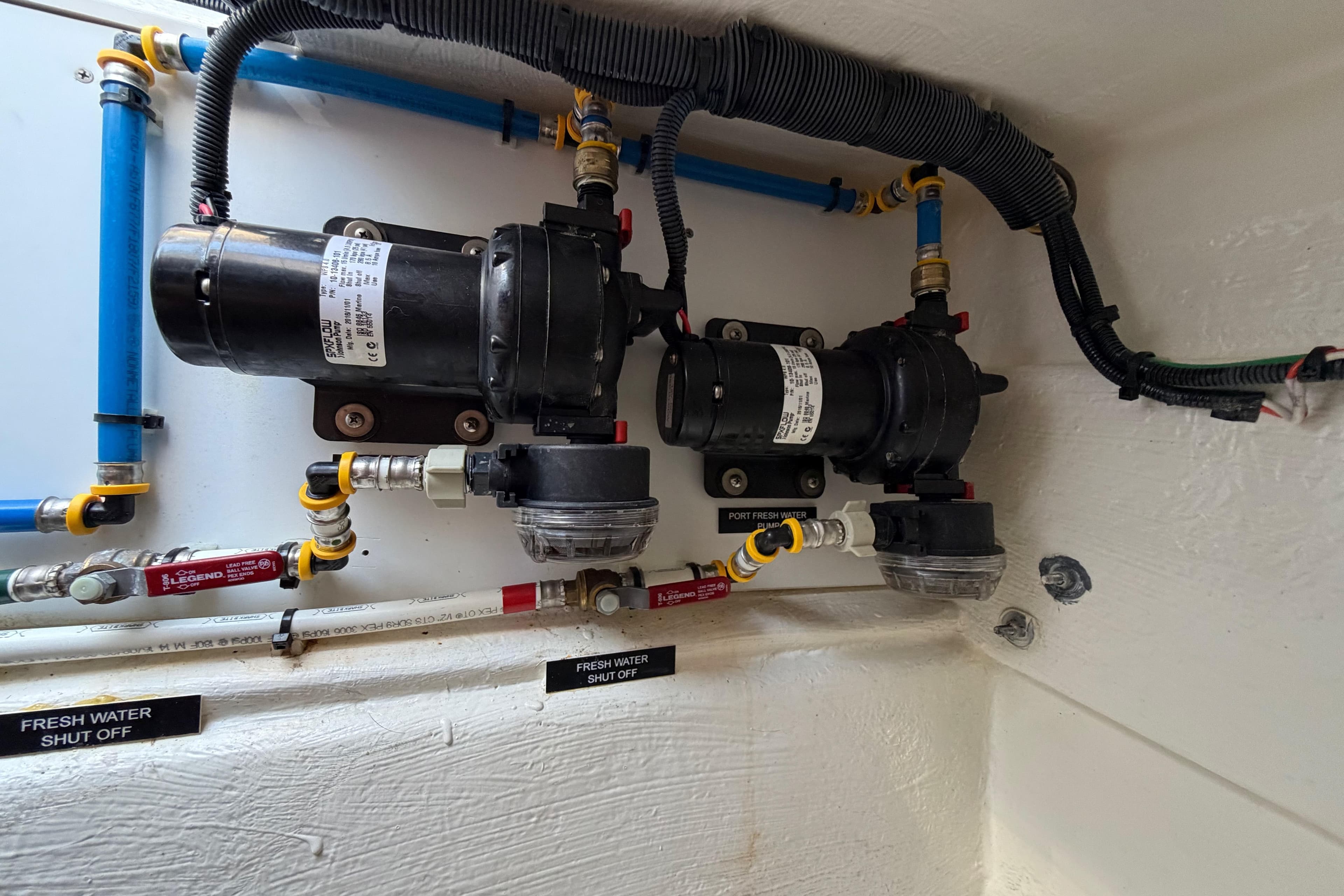 Freshwater plumbing system in a 2017 Aspen C120 boat, featuring shut-off valves and pumps.