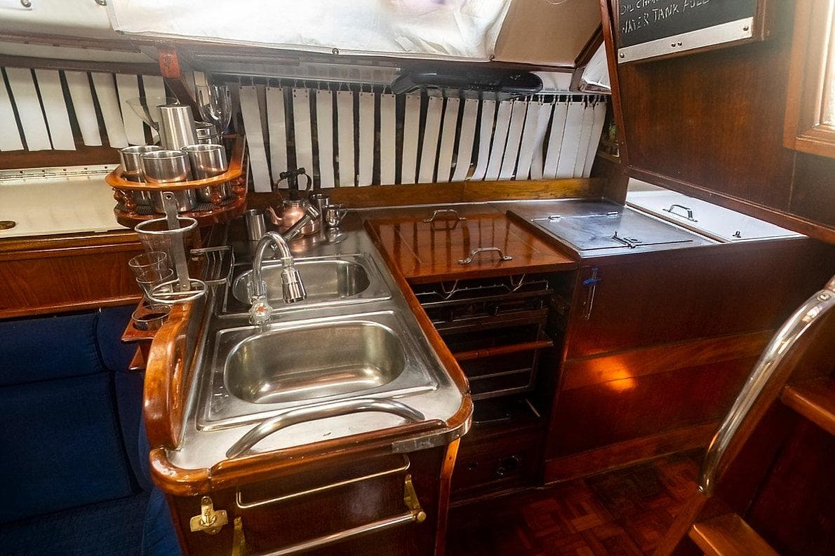 1992 Bowman 47 yacht kitchen with wooden cabinetry and stainless steel sink.